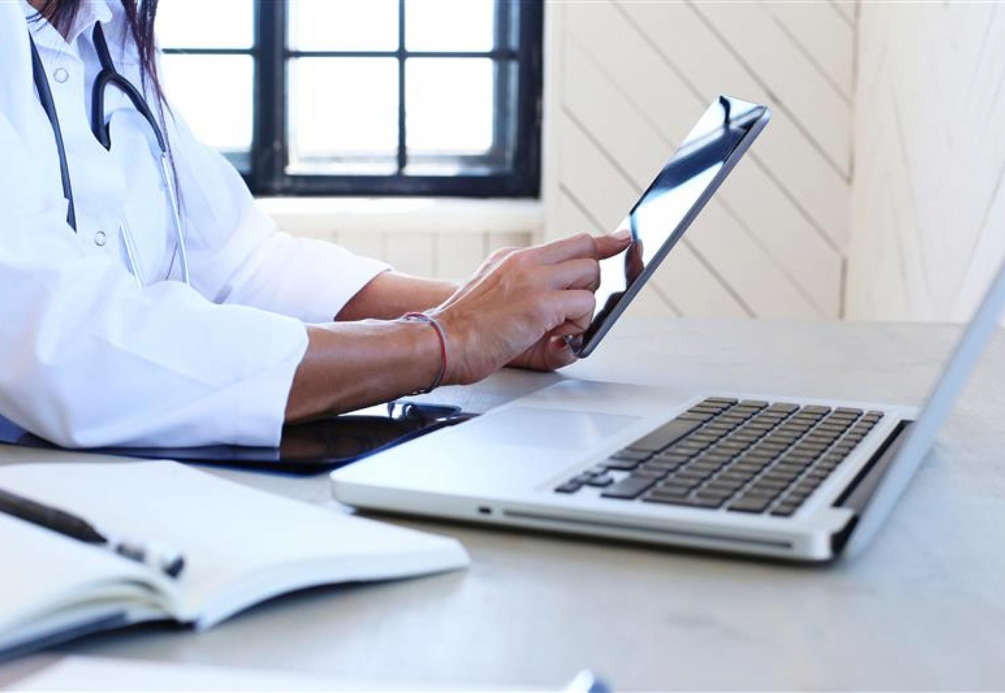 Person using laptop and digital tablet