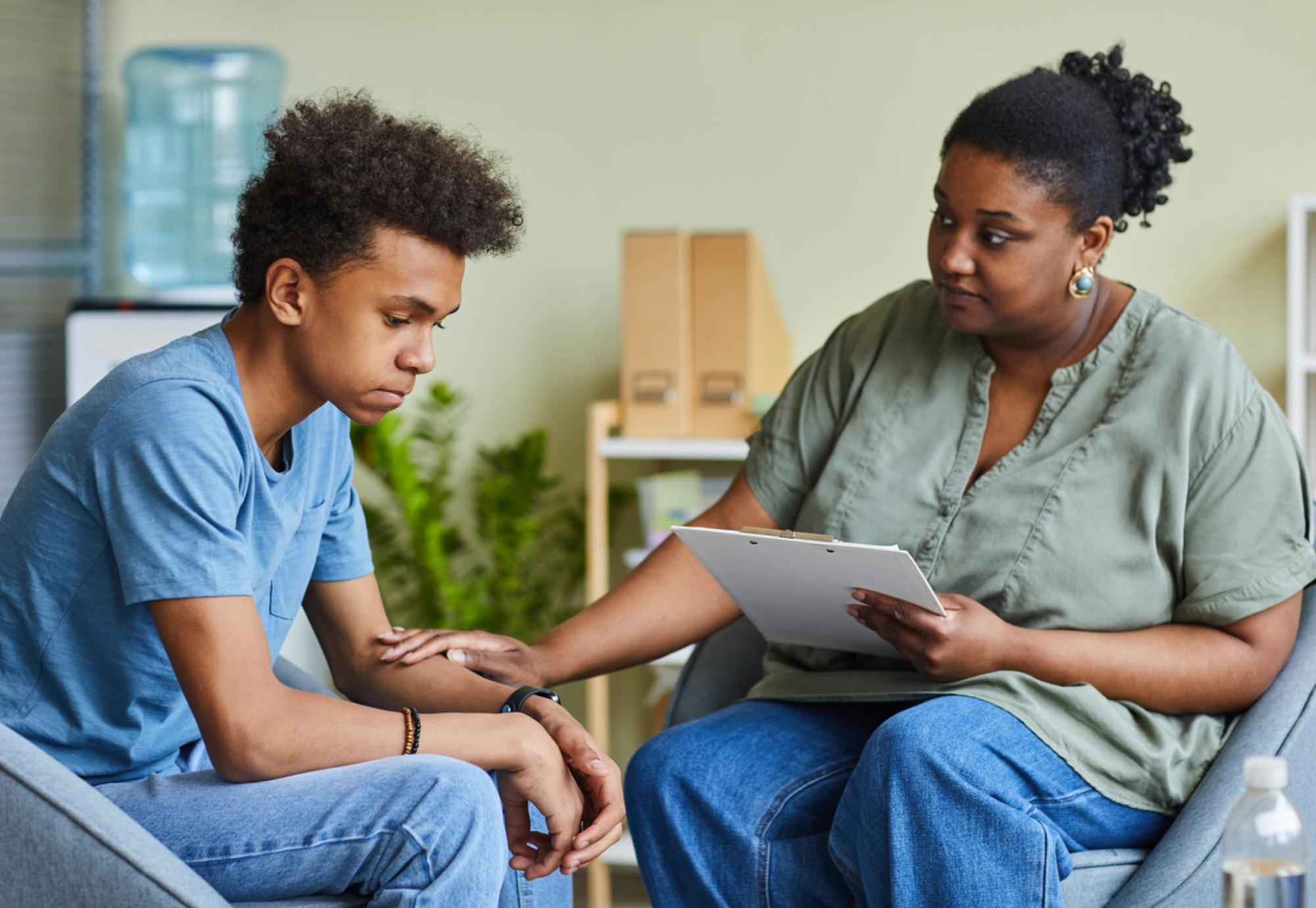 Psychologist with young boy in an office