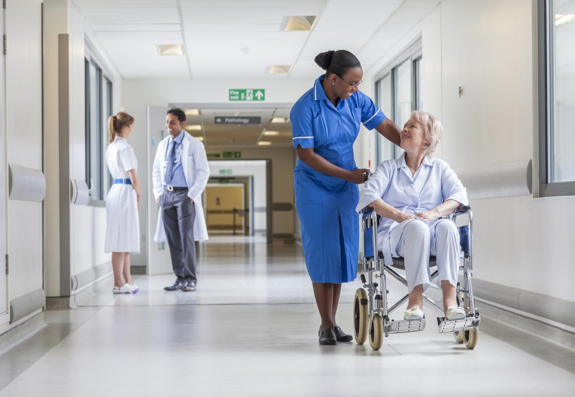 Elderly female patient in wheelchair with nurse