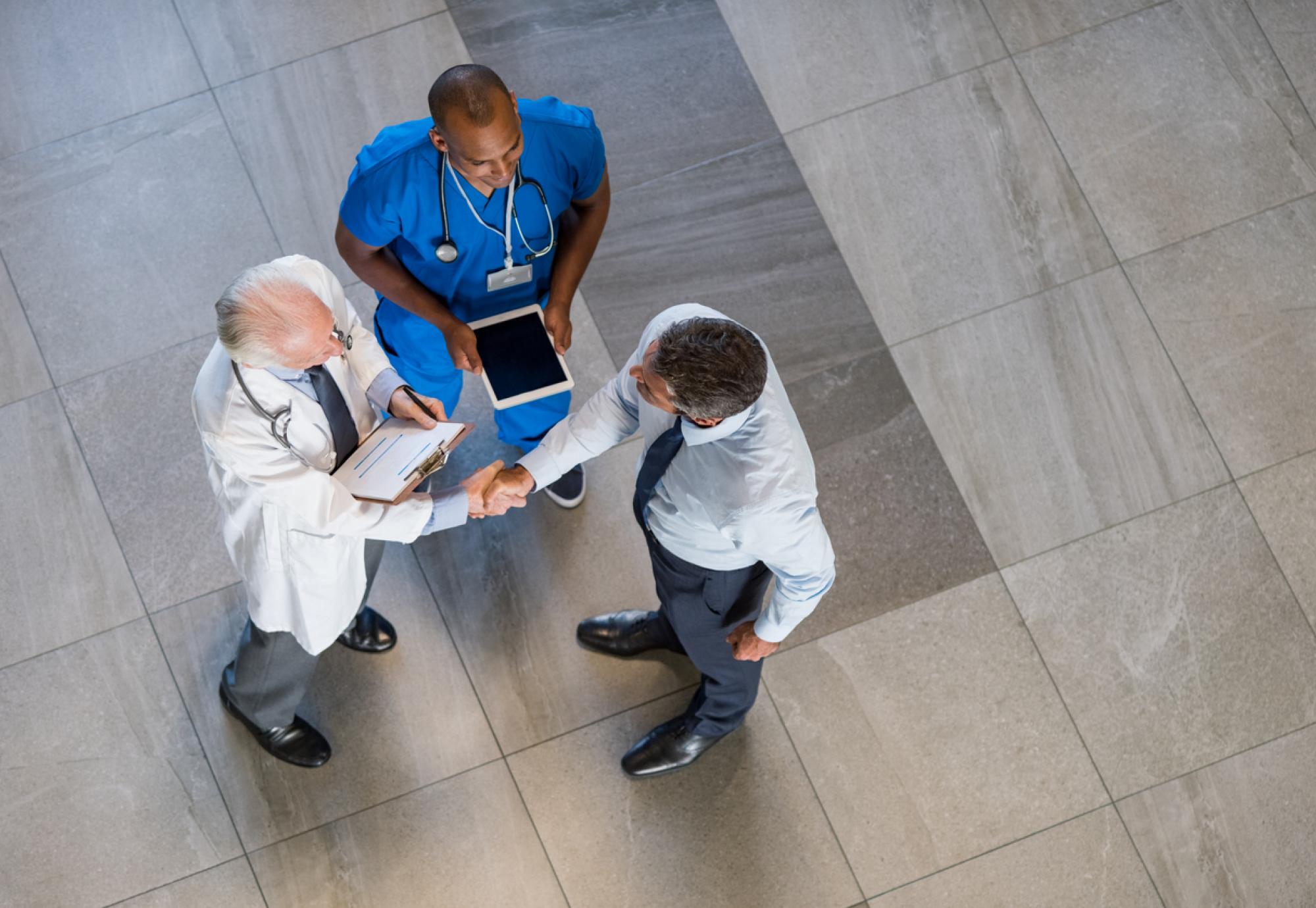 Overhead view of health professionals in agreement and shaking hands