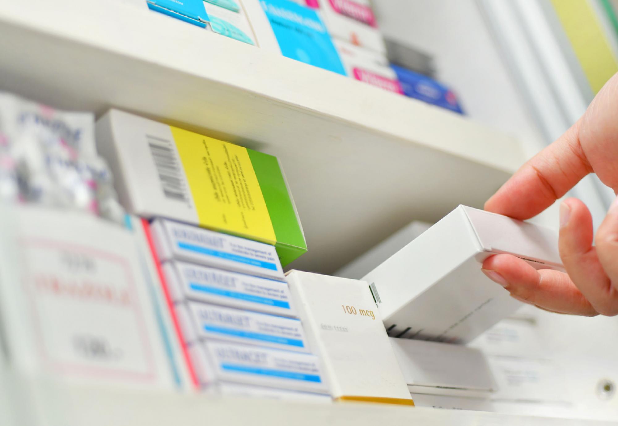 Close-up of a pharmacist's hand holding a medicine box