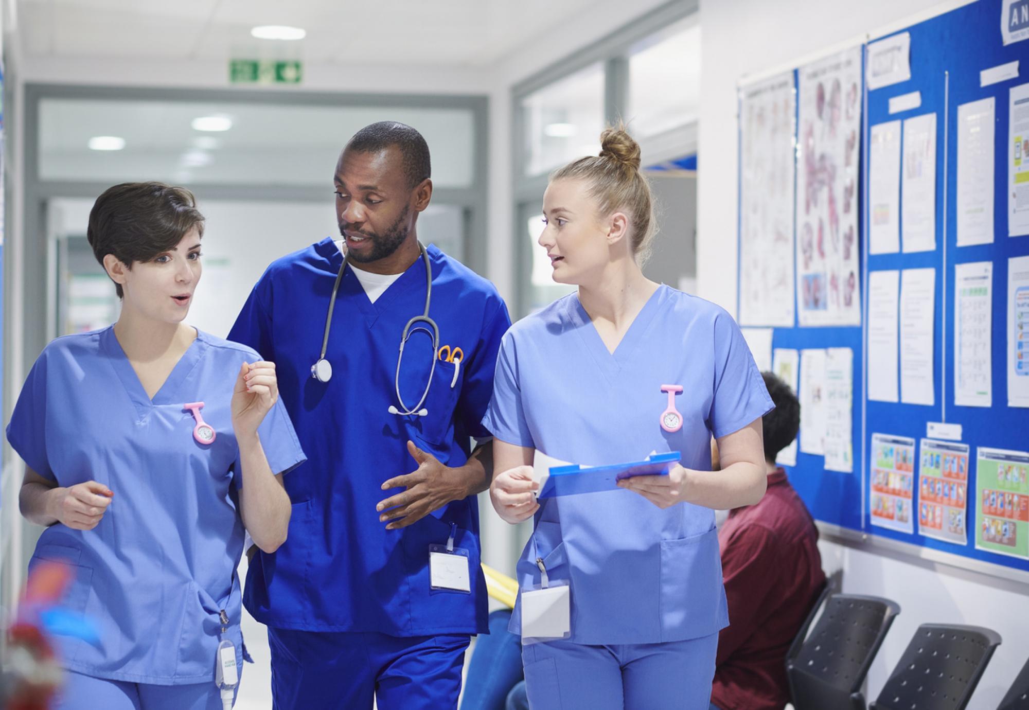 Health professionals walking through corridor and talking