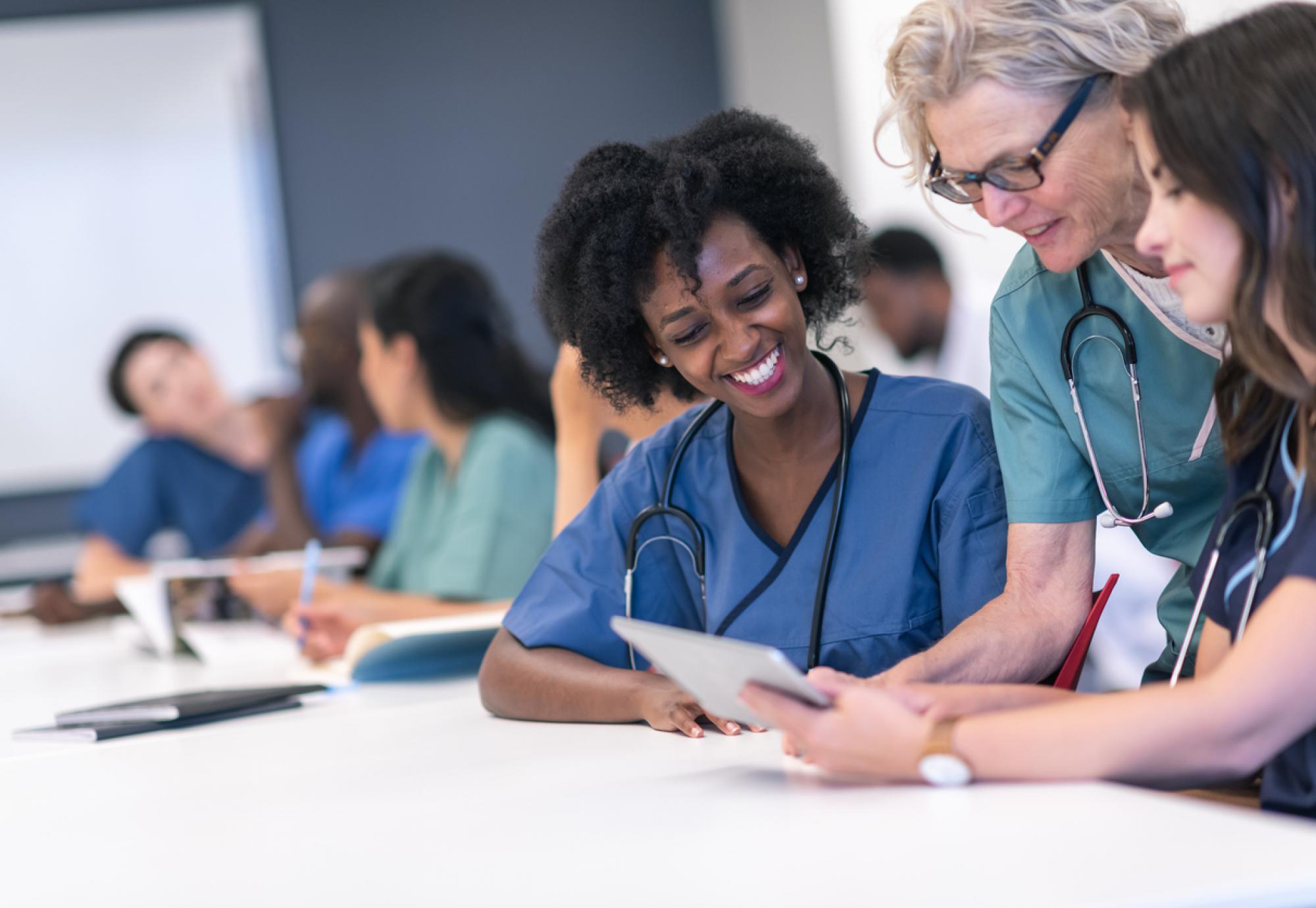 Senior female lecturer assists medical students during class