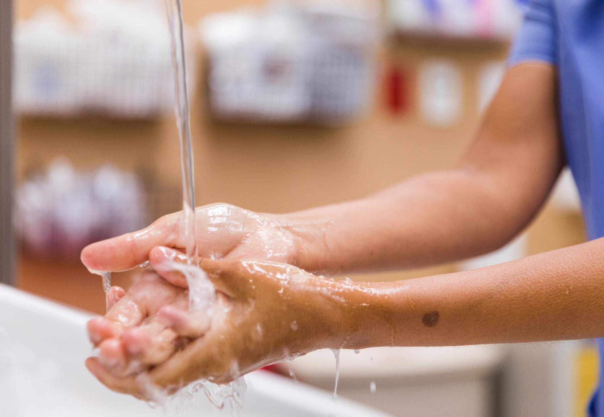 Healthcare worker washing their hands with water
