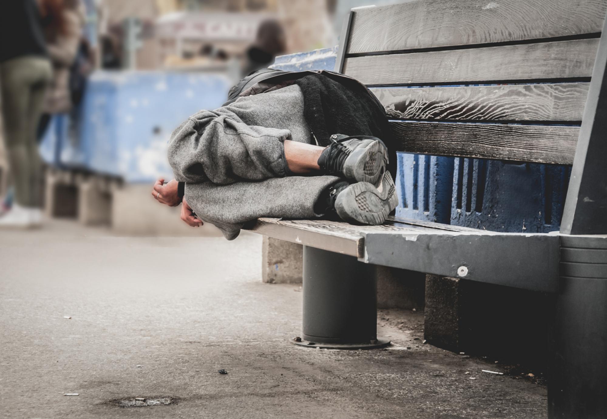 Homeless man sleeping on bench