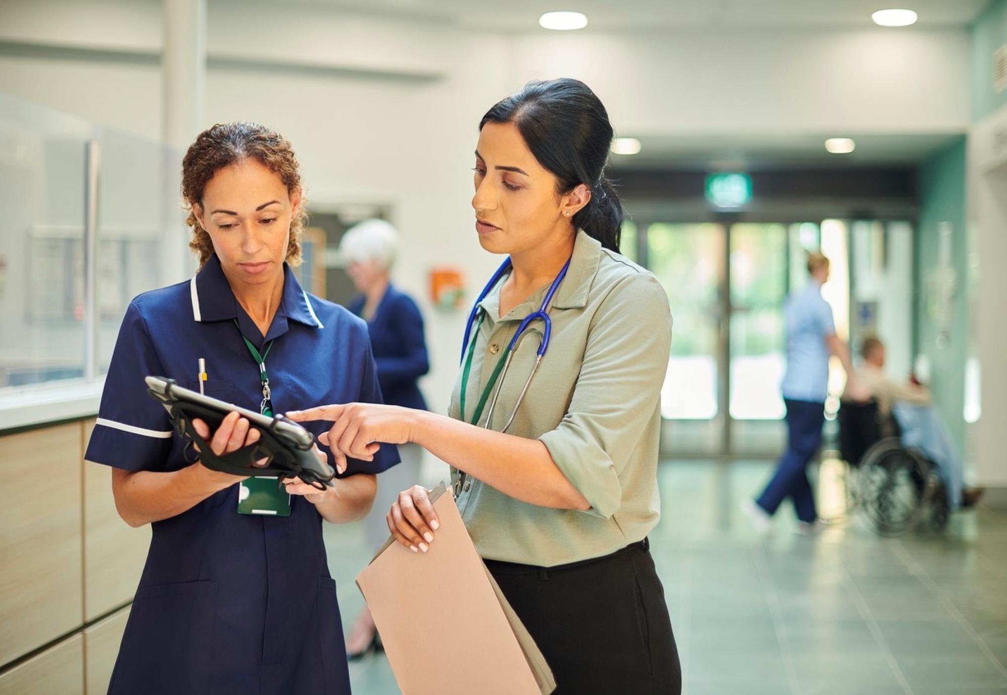 Health professionals analysing medical records on digital tablet