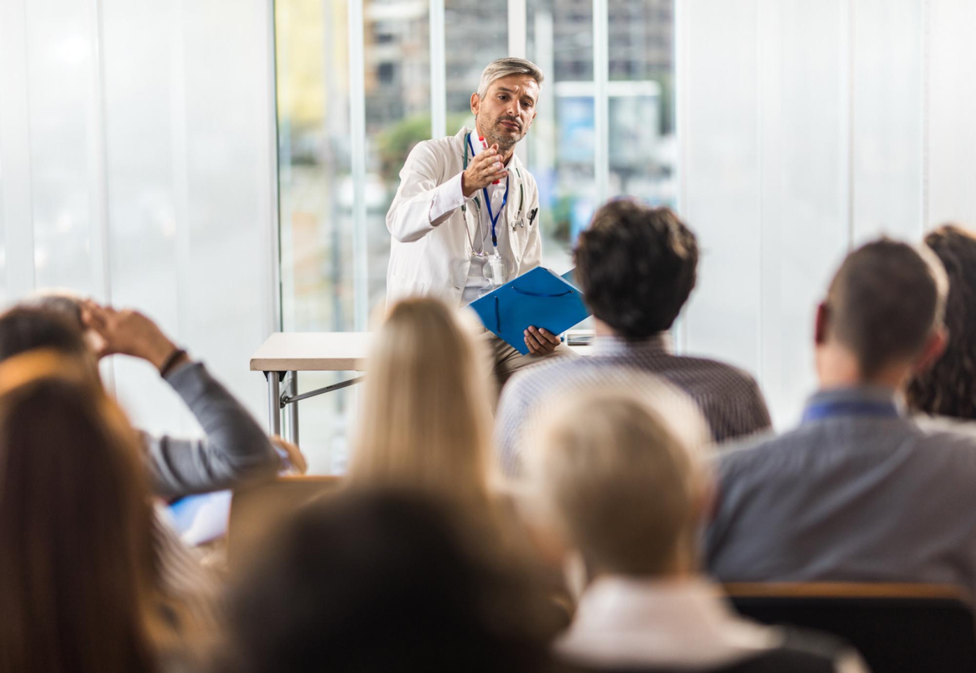 Health professional teaching students in a board room