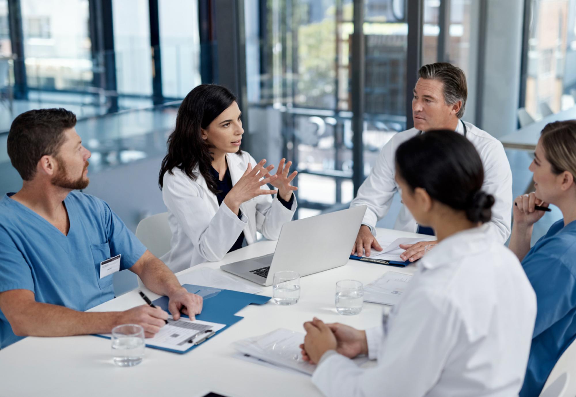 Healthcare professionals sat around a table having a meeting