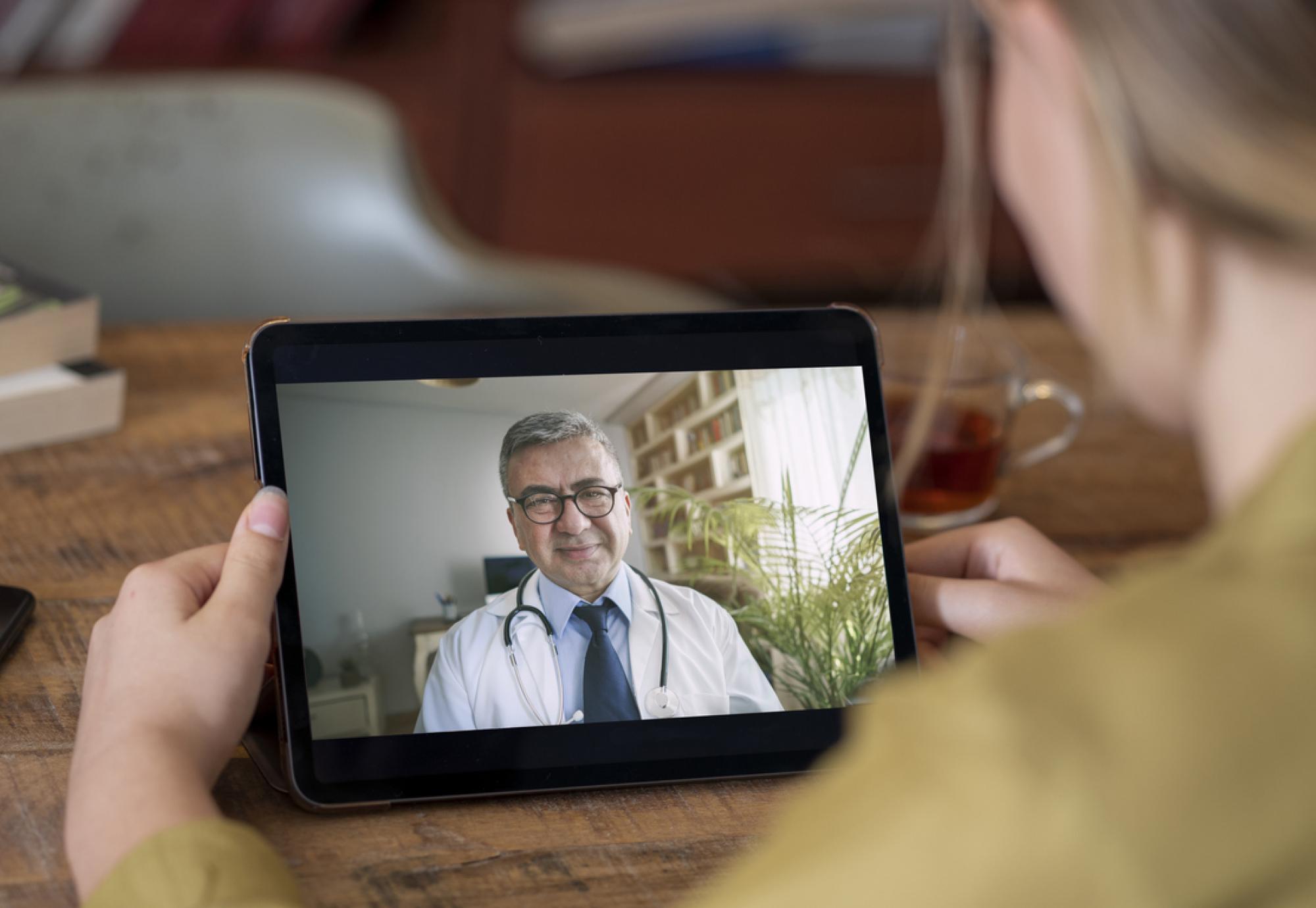 Doctor and patient talking on video call using digital tablet