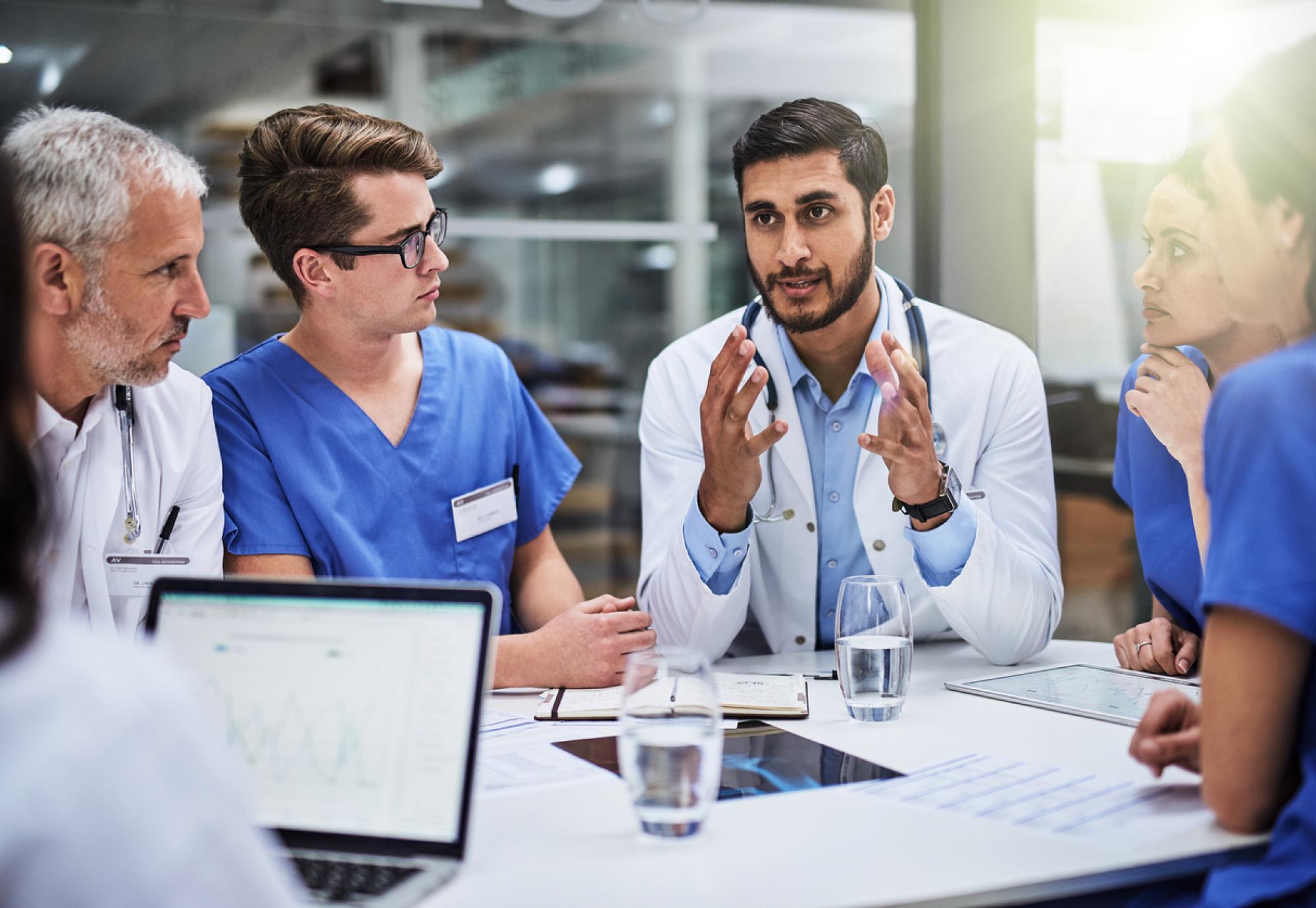 Group of health professionals talking around a table