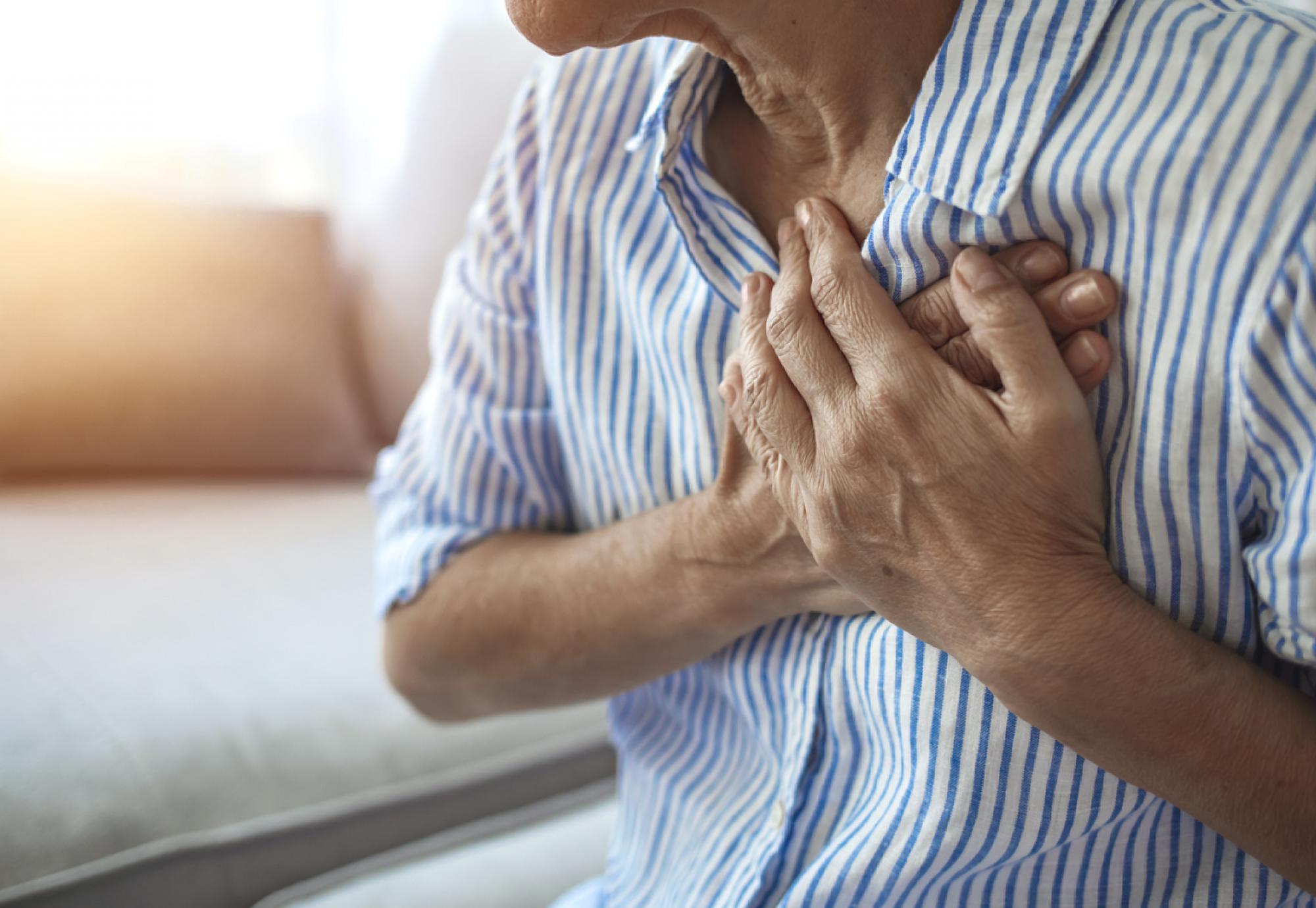 Man holding chest with heart condition