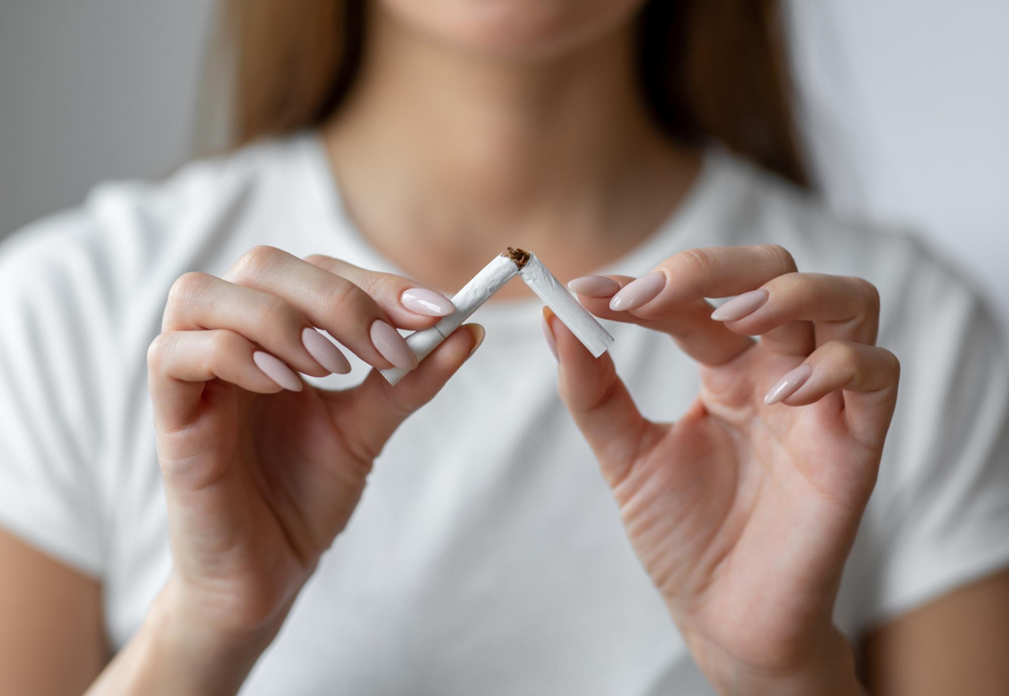 Woman breaking a cigarette in half