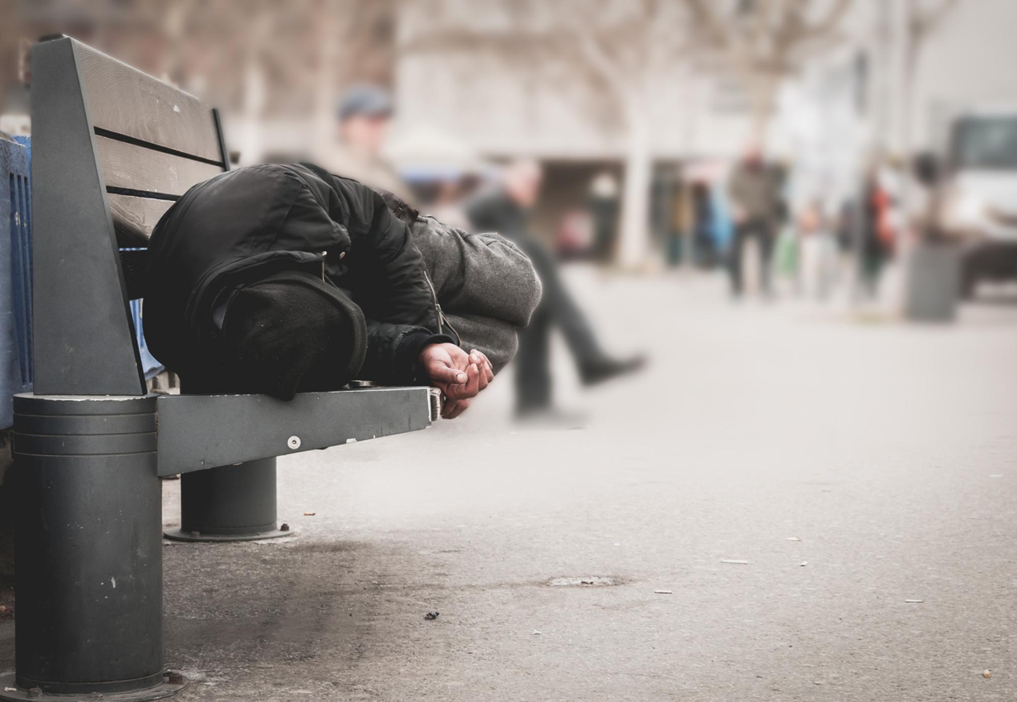 Homeless man sleeping on bench