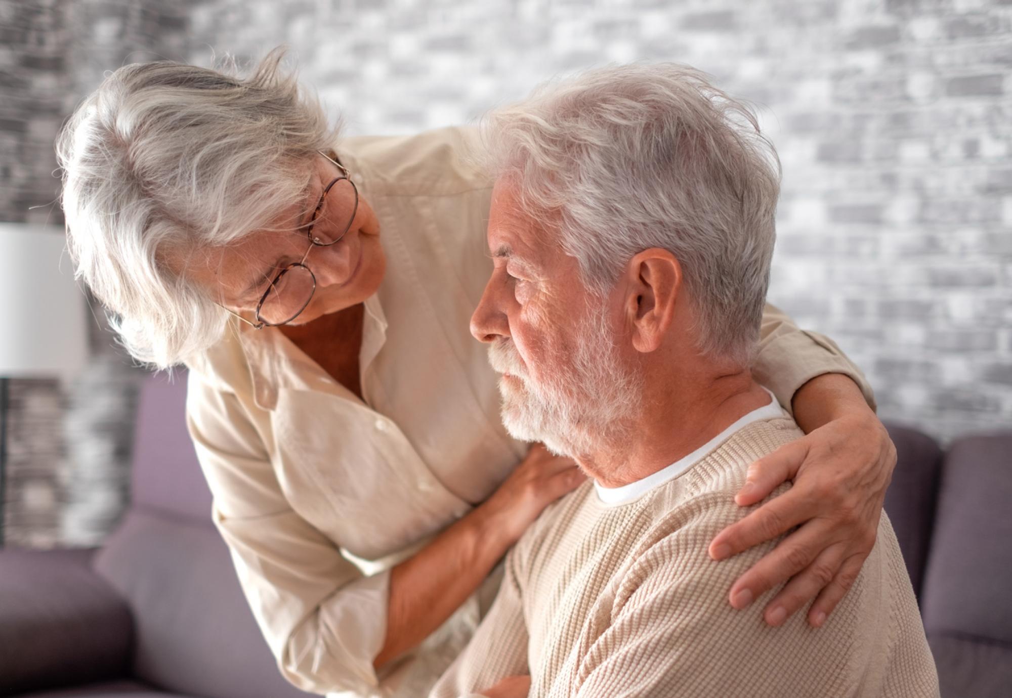 Elderly lady comforting her husband