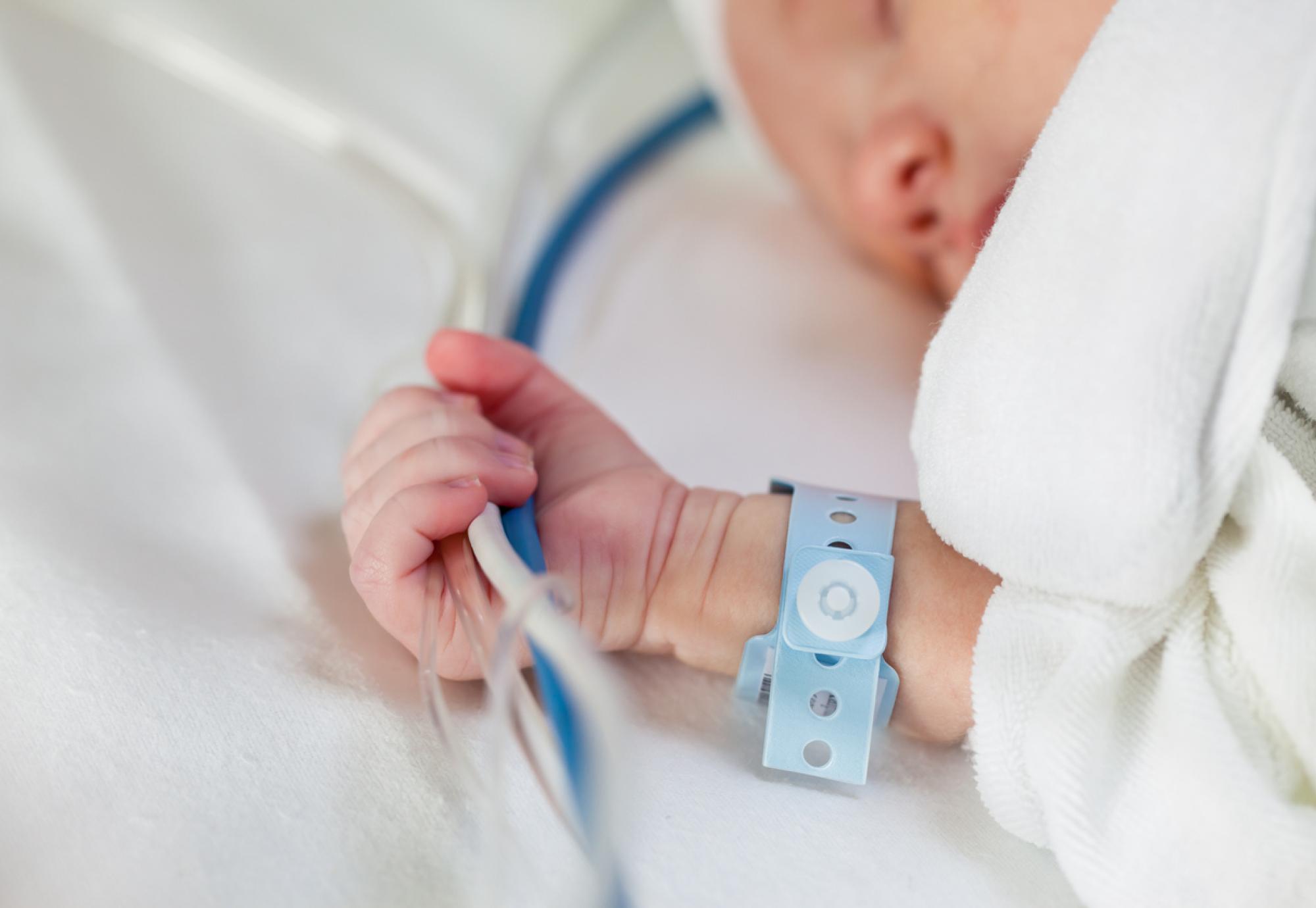 Newborn baby in hospital bed