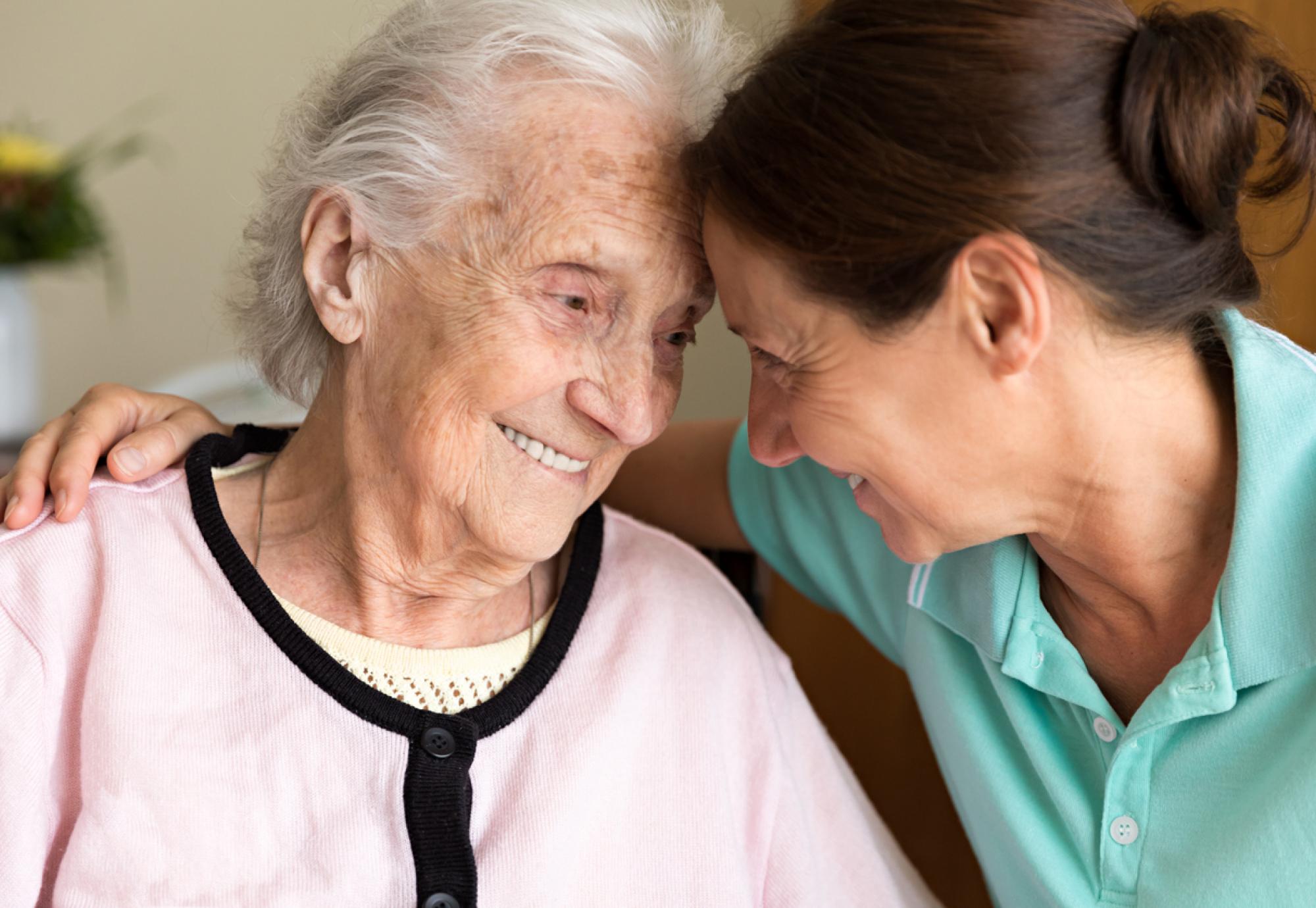 Home care giver comforting elderly patient