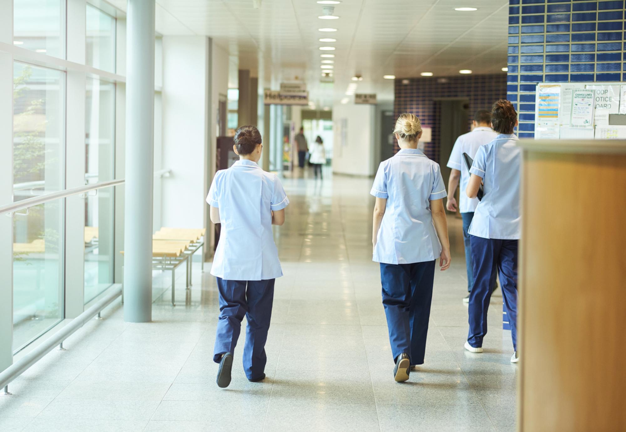 Groups of nurse walking down a corridor depicting the NHS workforce