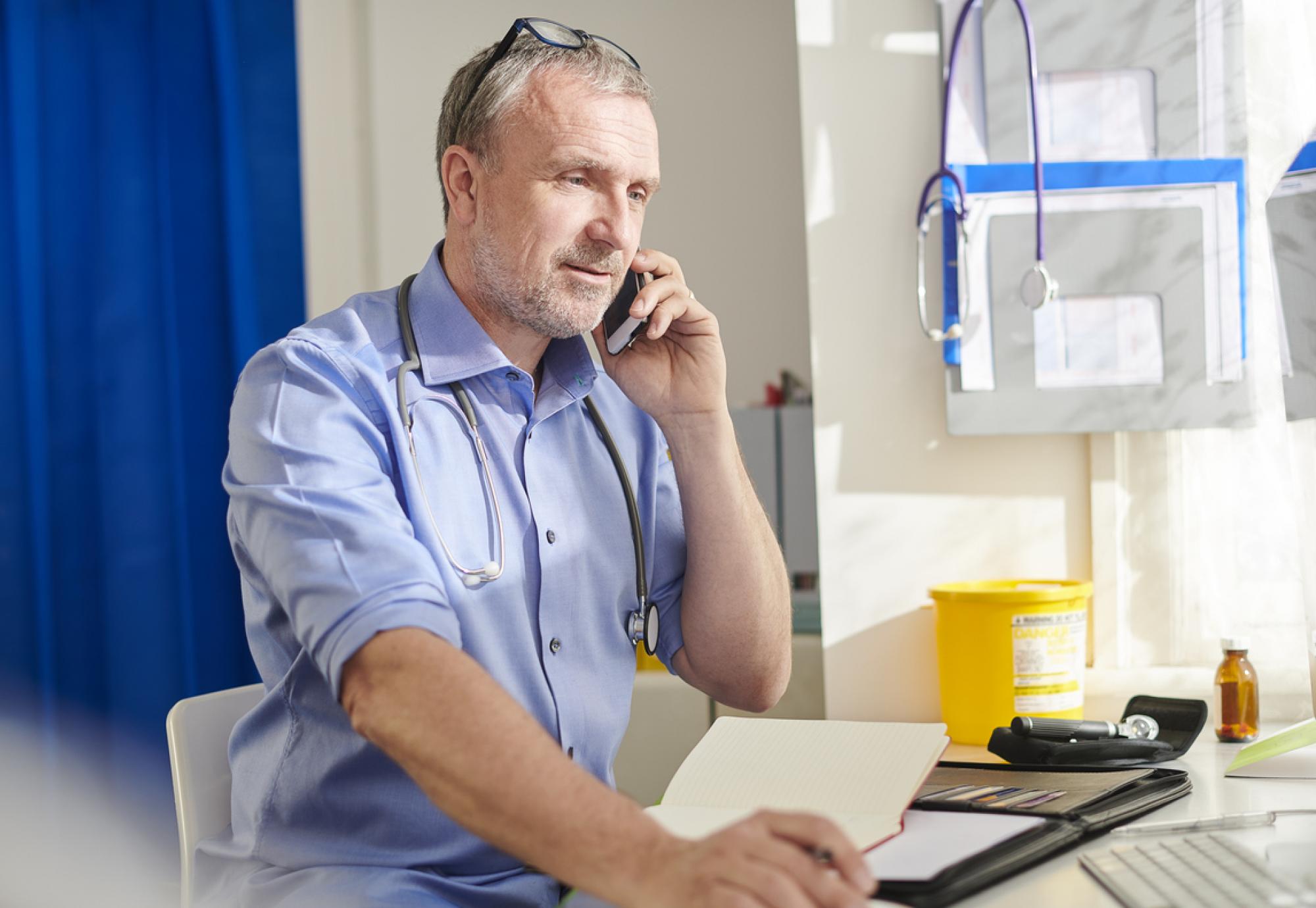 Doctor on the phone depicting new digital transformation upgrade for GP practices