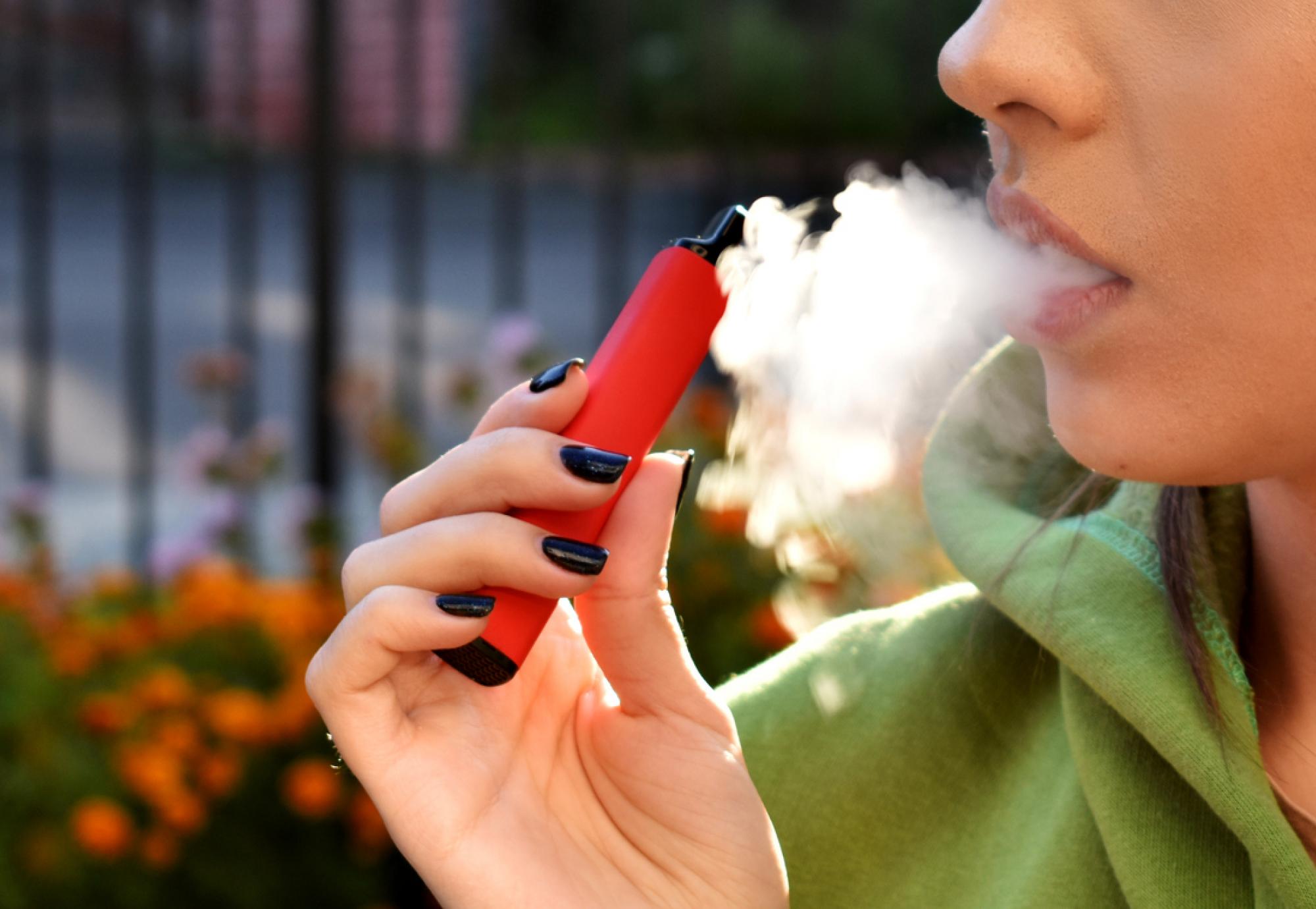 Woman using e-cigarette to try and quit smoking