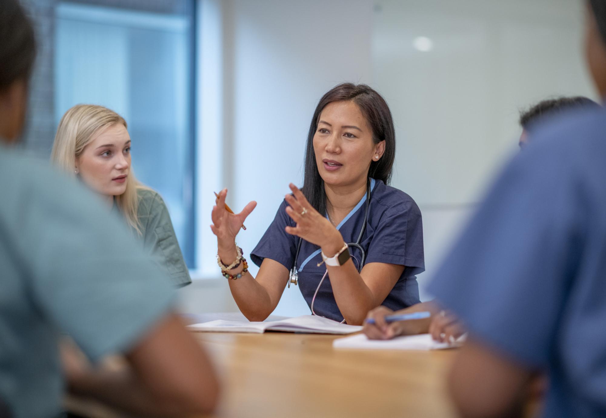 Healthcare professionals sat around a table having a meeting