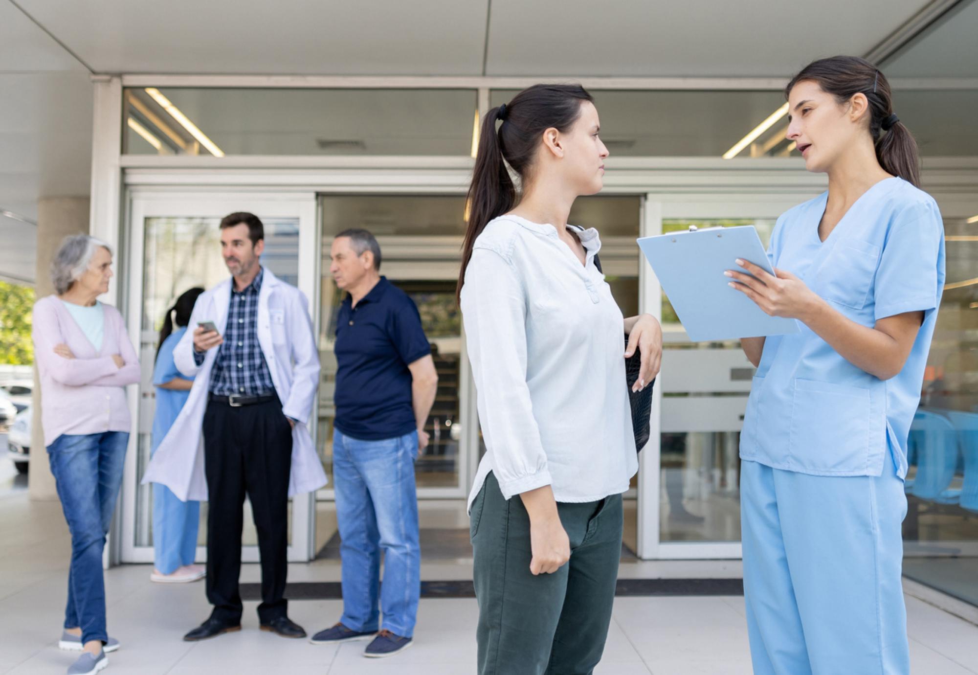 Health professionals and patients talking outside of an NHS estate following a patient discharge