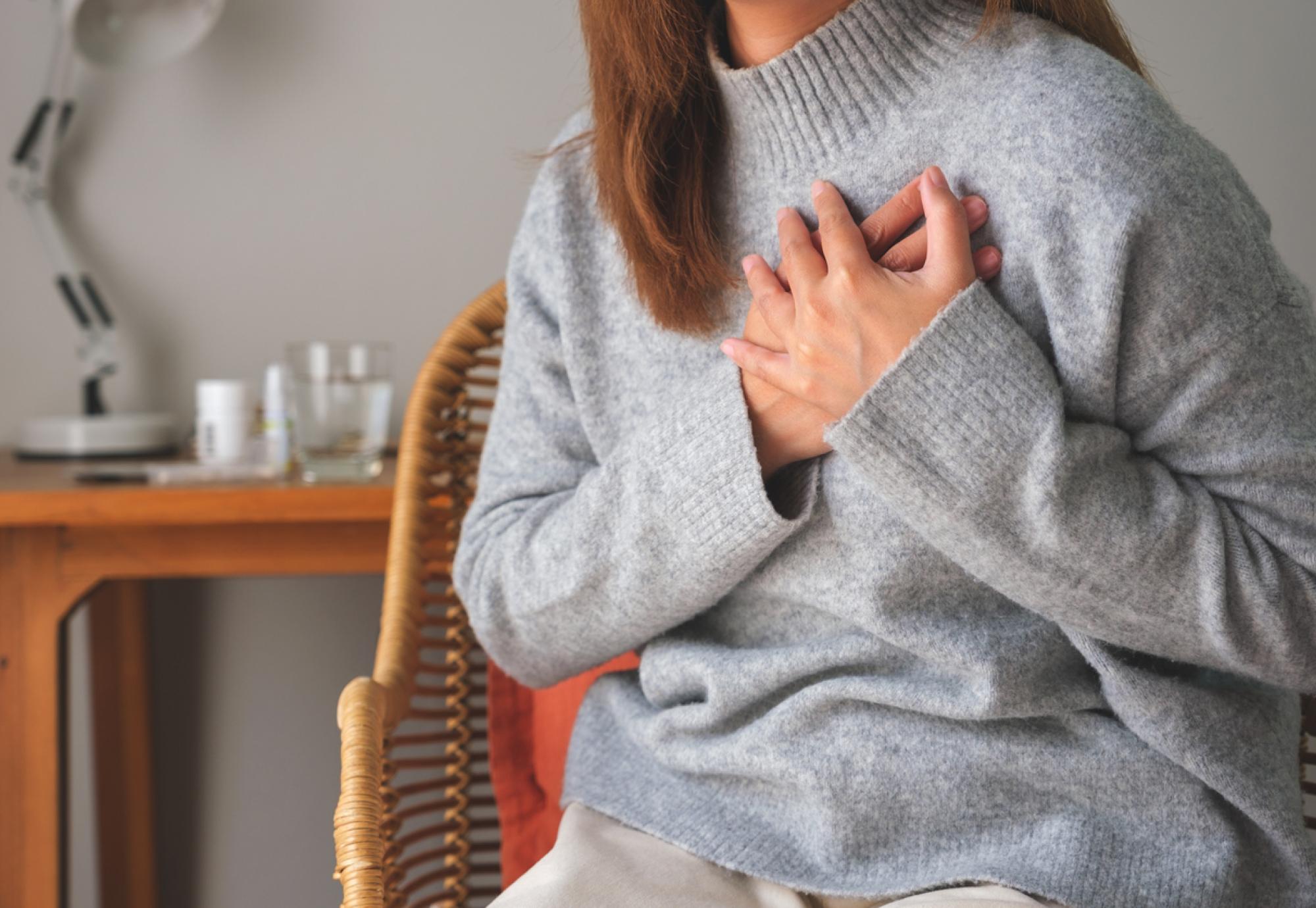 Woman clutching the left side of her chest