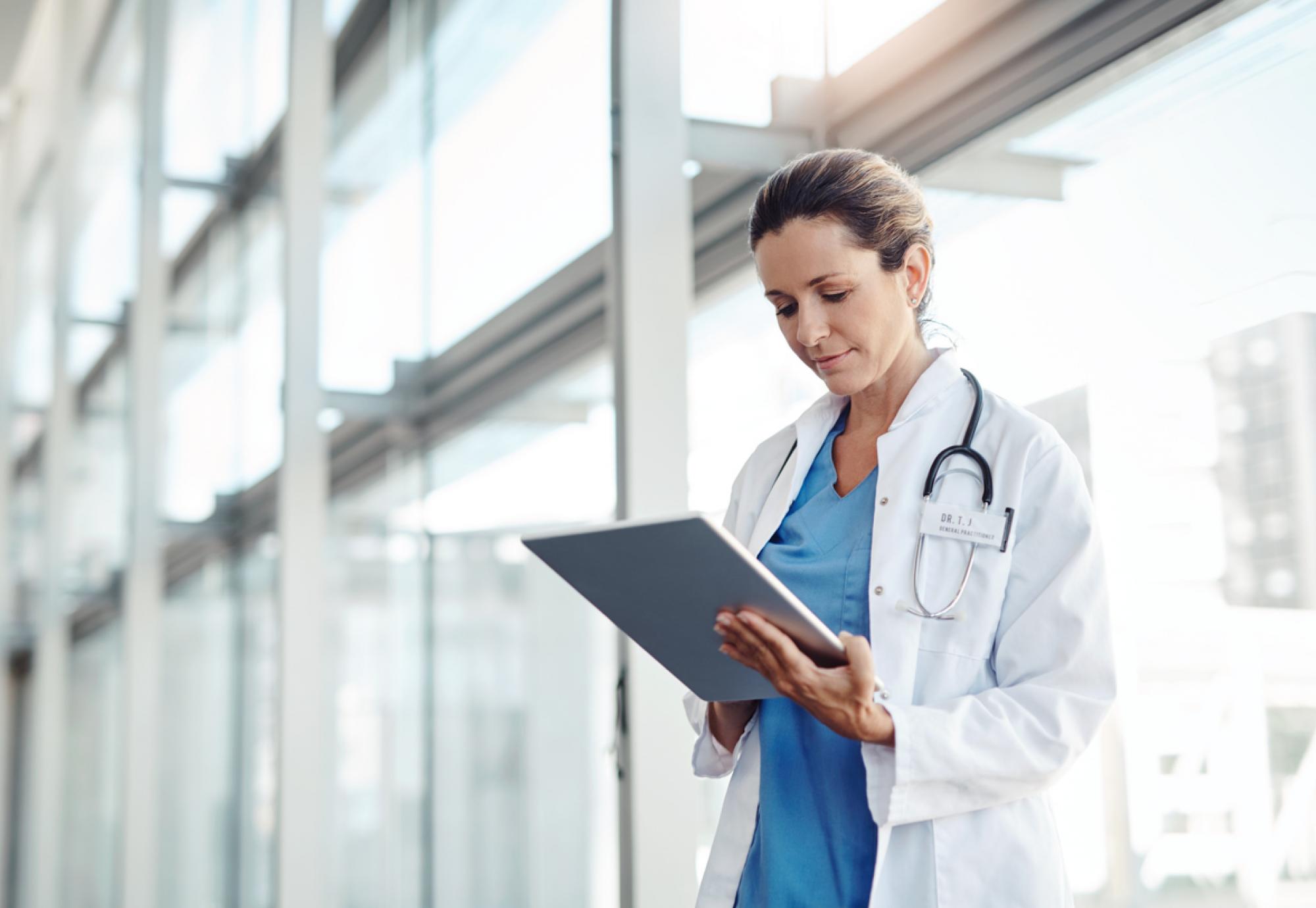 Man holding tablet depicting digital health and virtual ward technology