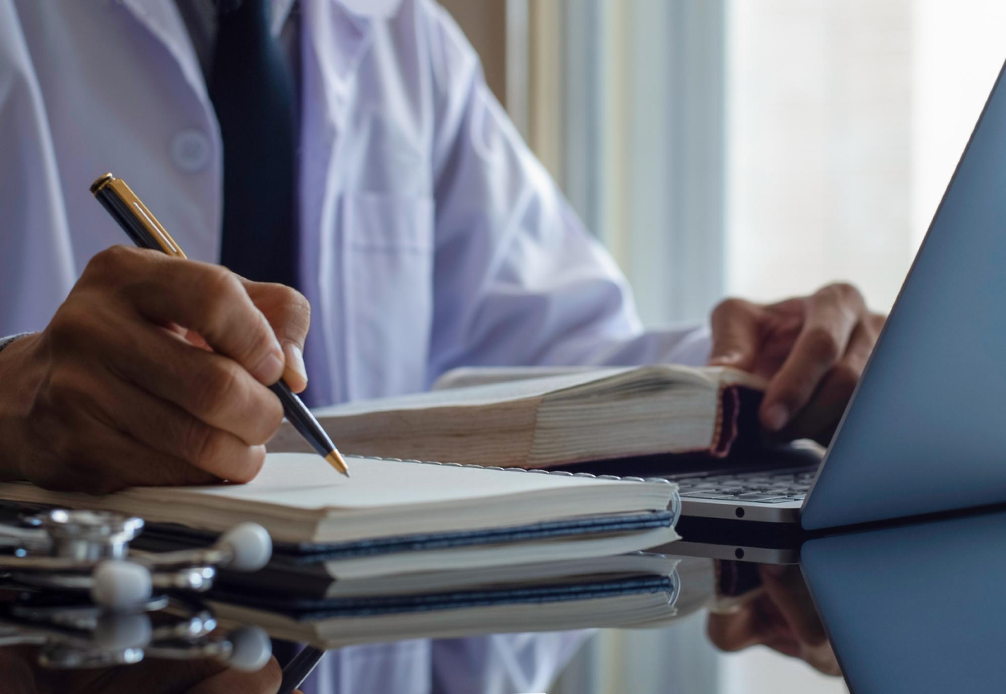 Doctor writing a report depicting the new sexual safety charter to protect NHS staff