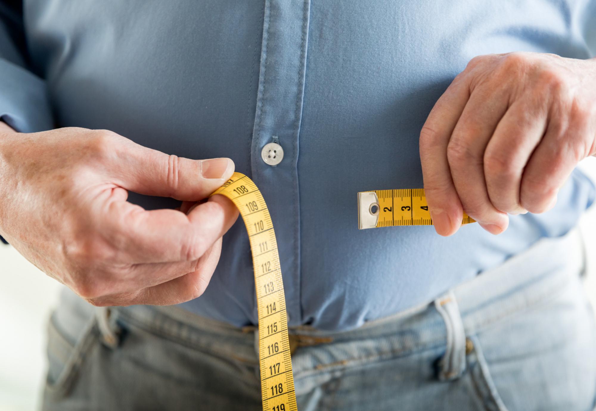 Person measuring their waist depicting type 2 diabetes treatment