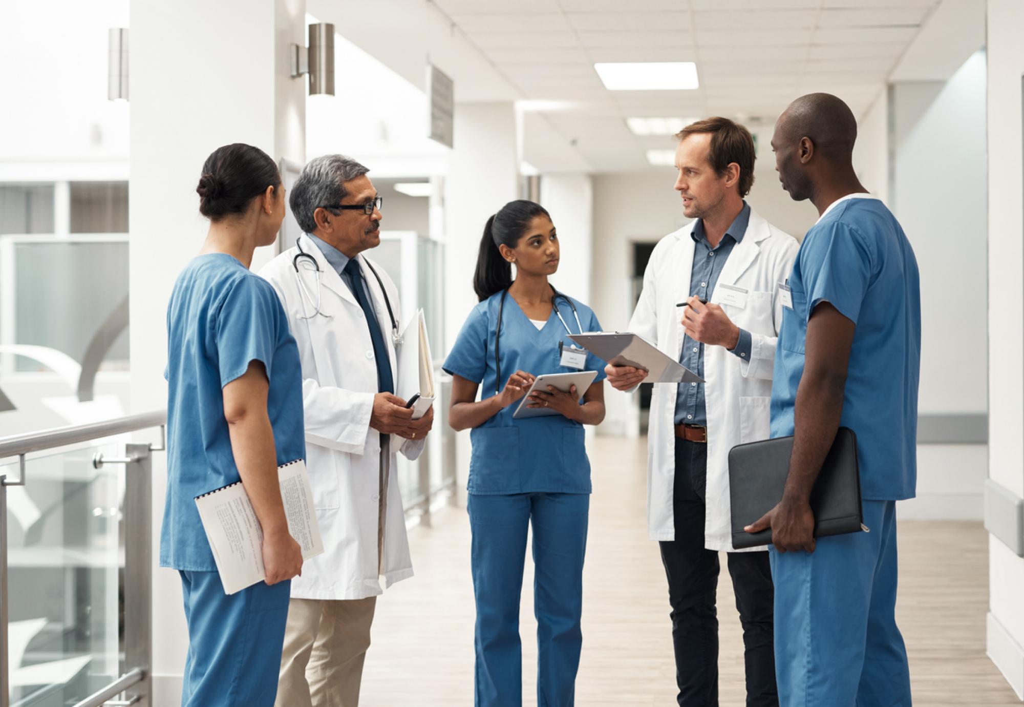 Group of healthcare professionals talking in a group depicting patient data sharing