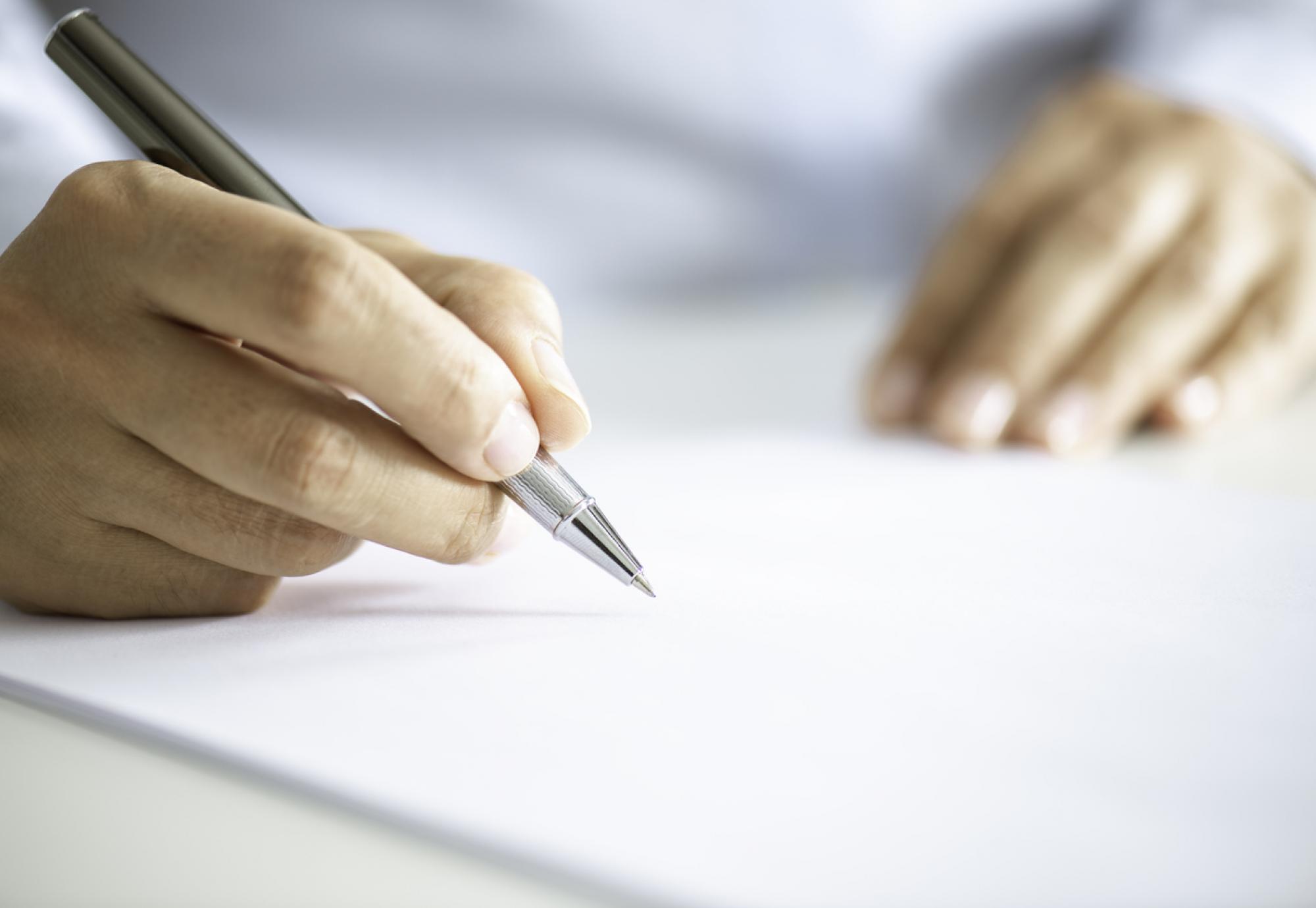 Image a person signing a contract depicting the NHS sexual safety charter