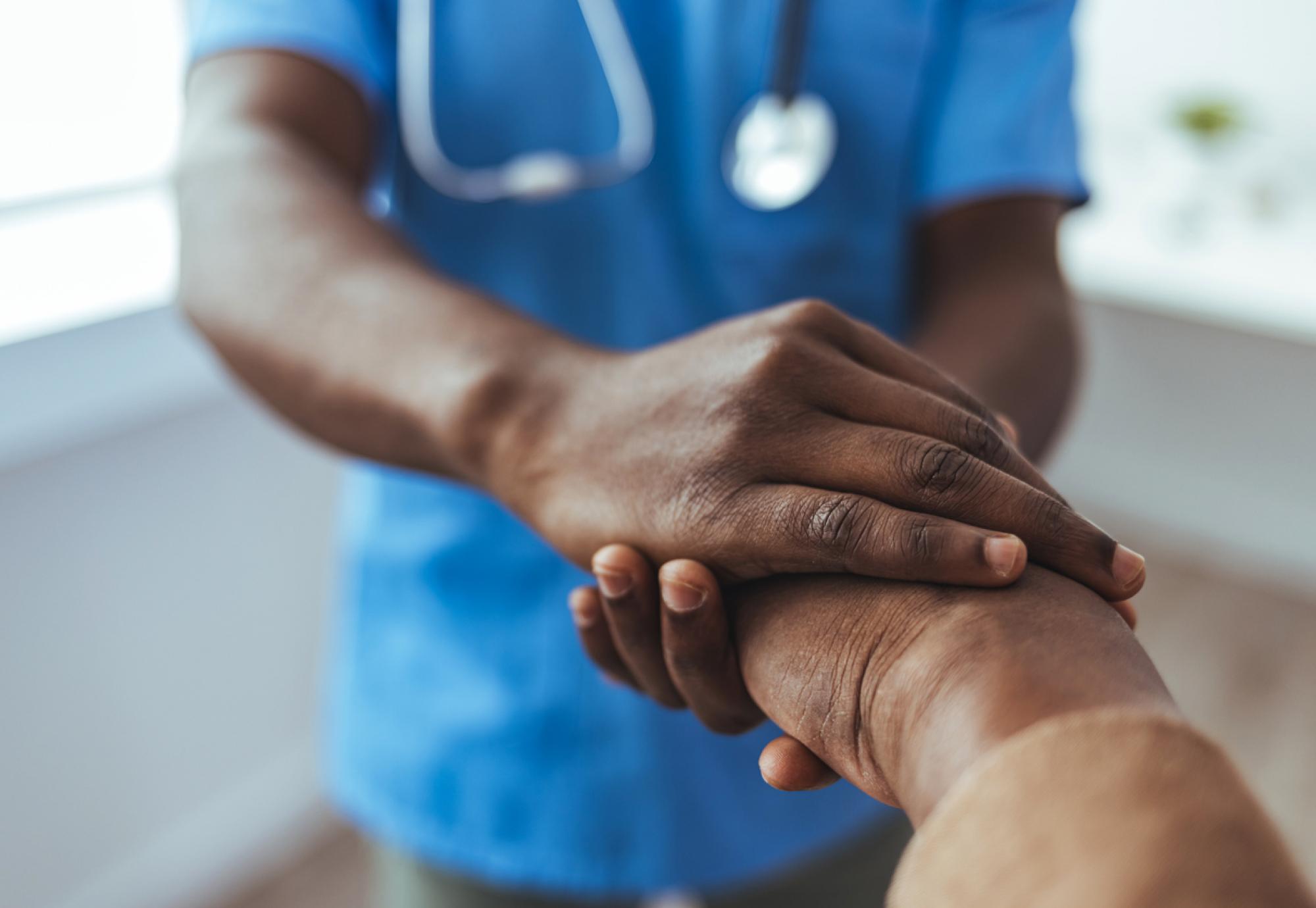 Image of a nursing holding the hand of patient depicting NICE's new guidance for NHS stroke patients