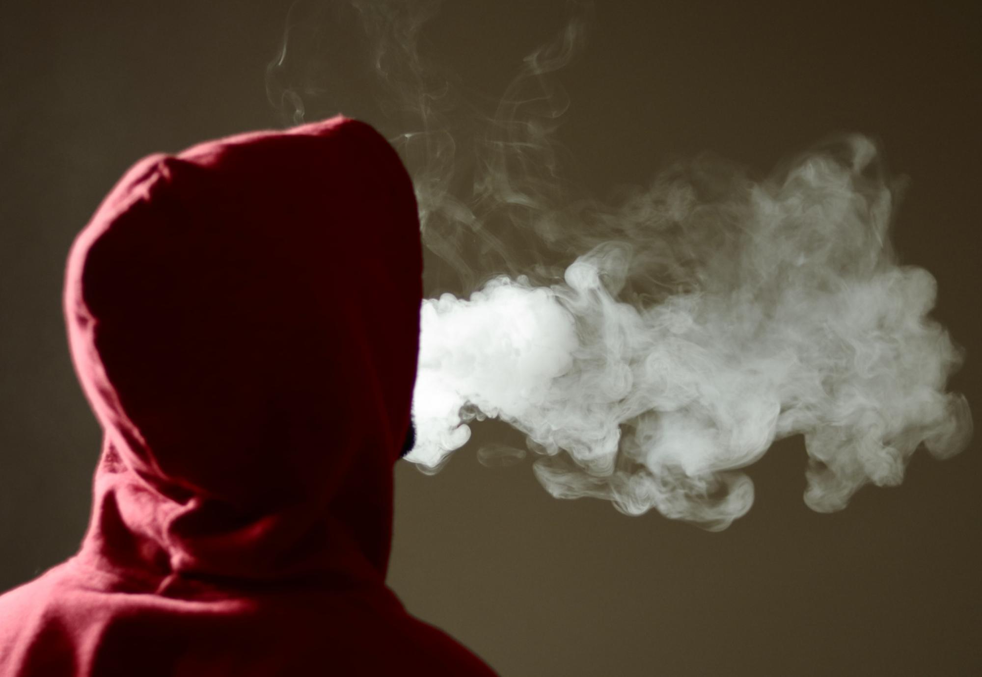 Image of a hooded figure smoking an e-cigarette depicting the UK government's youth vaping public consultation