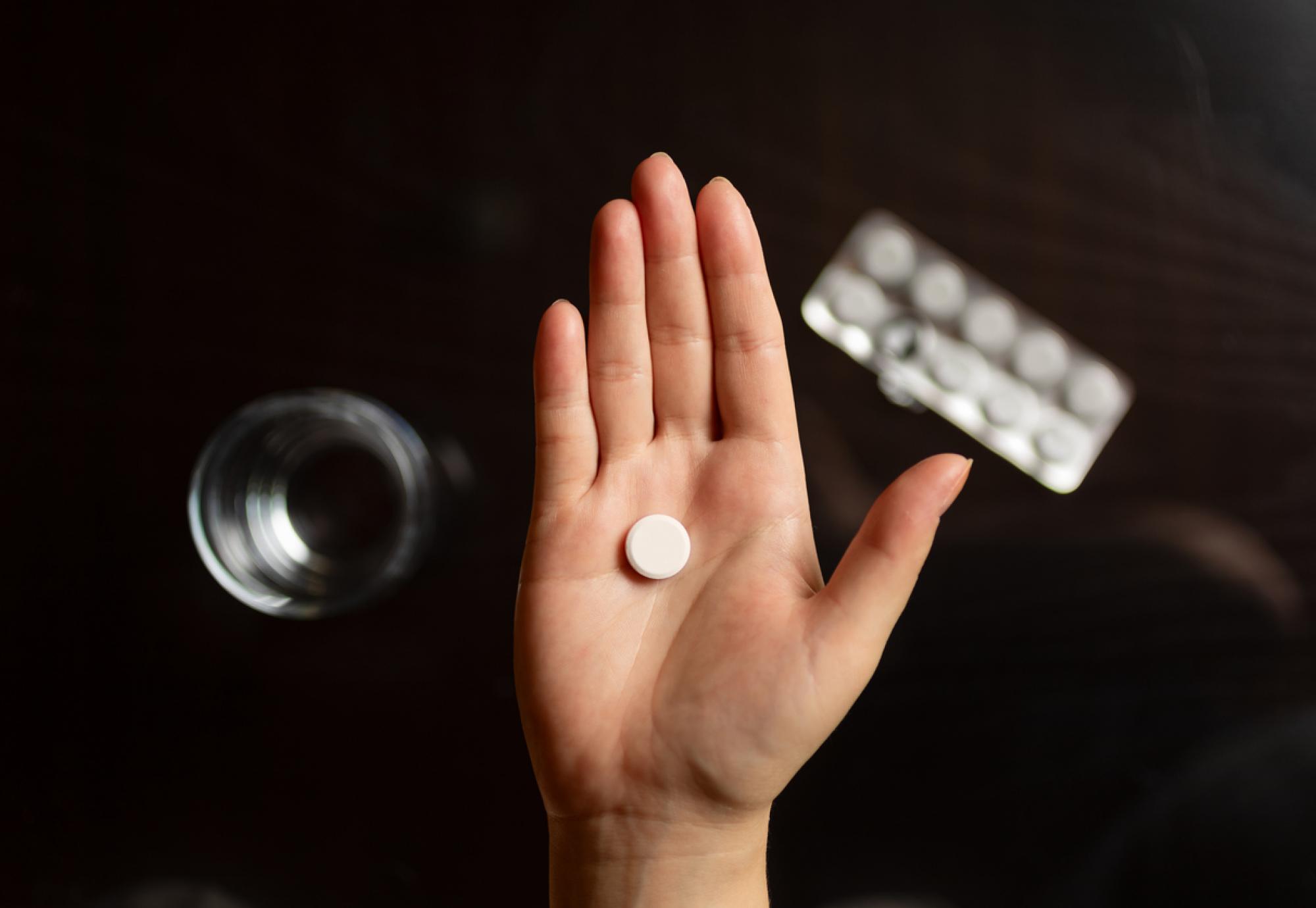 Close-up of hand holding a pill