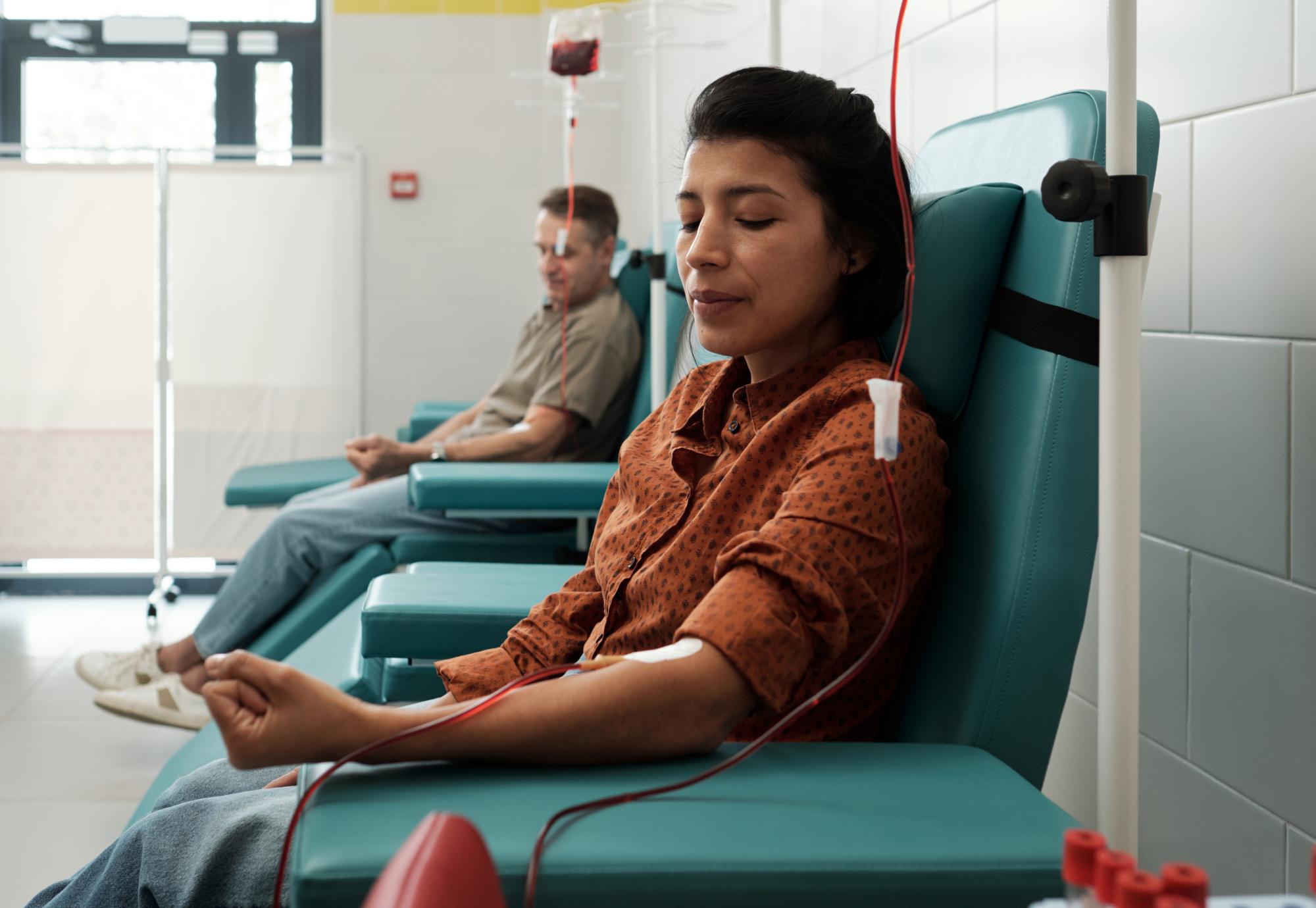 Young woman and mature man giving blood for sick patients