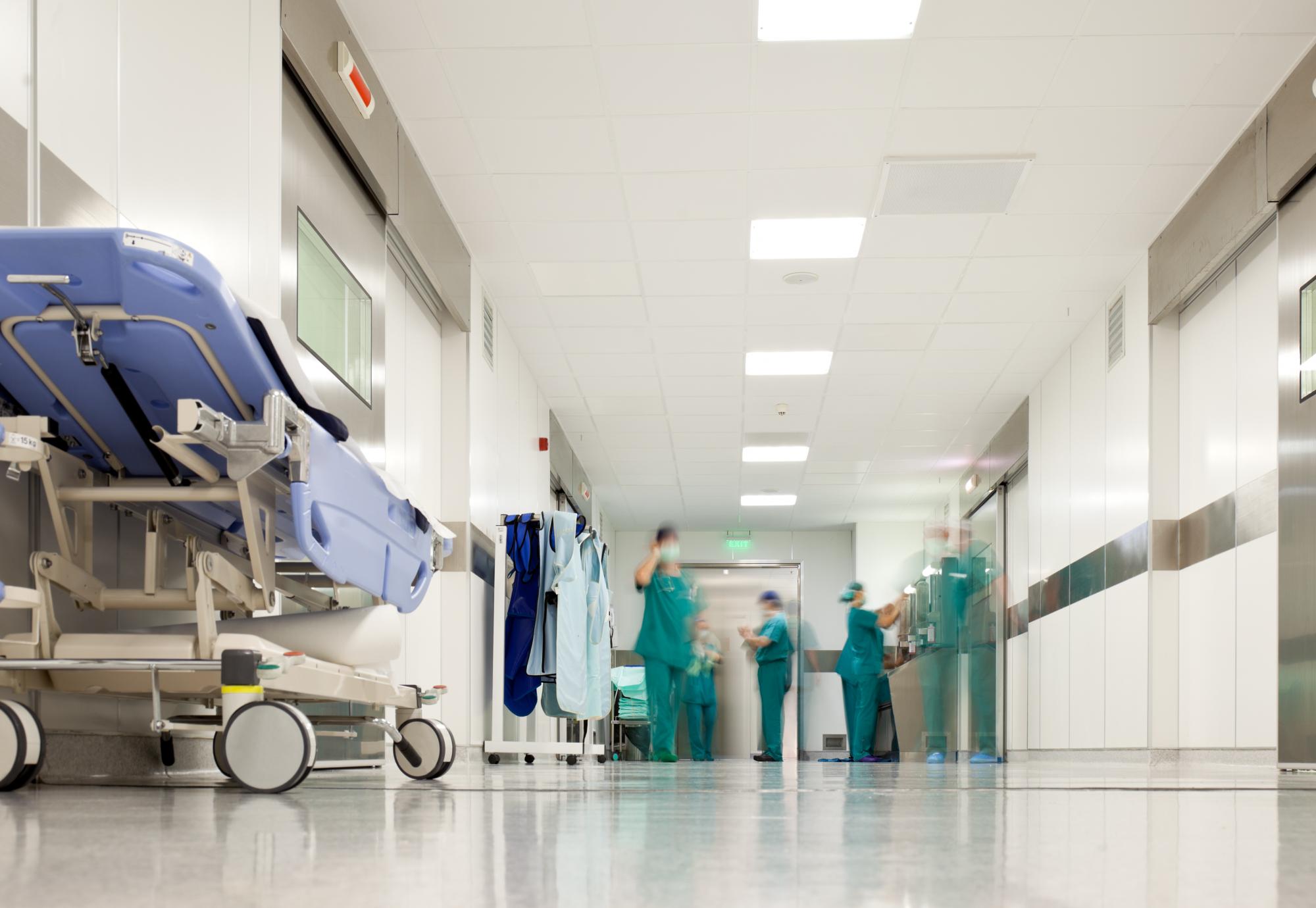 Blurred figures of people with medical uniforms in hospital corridor