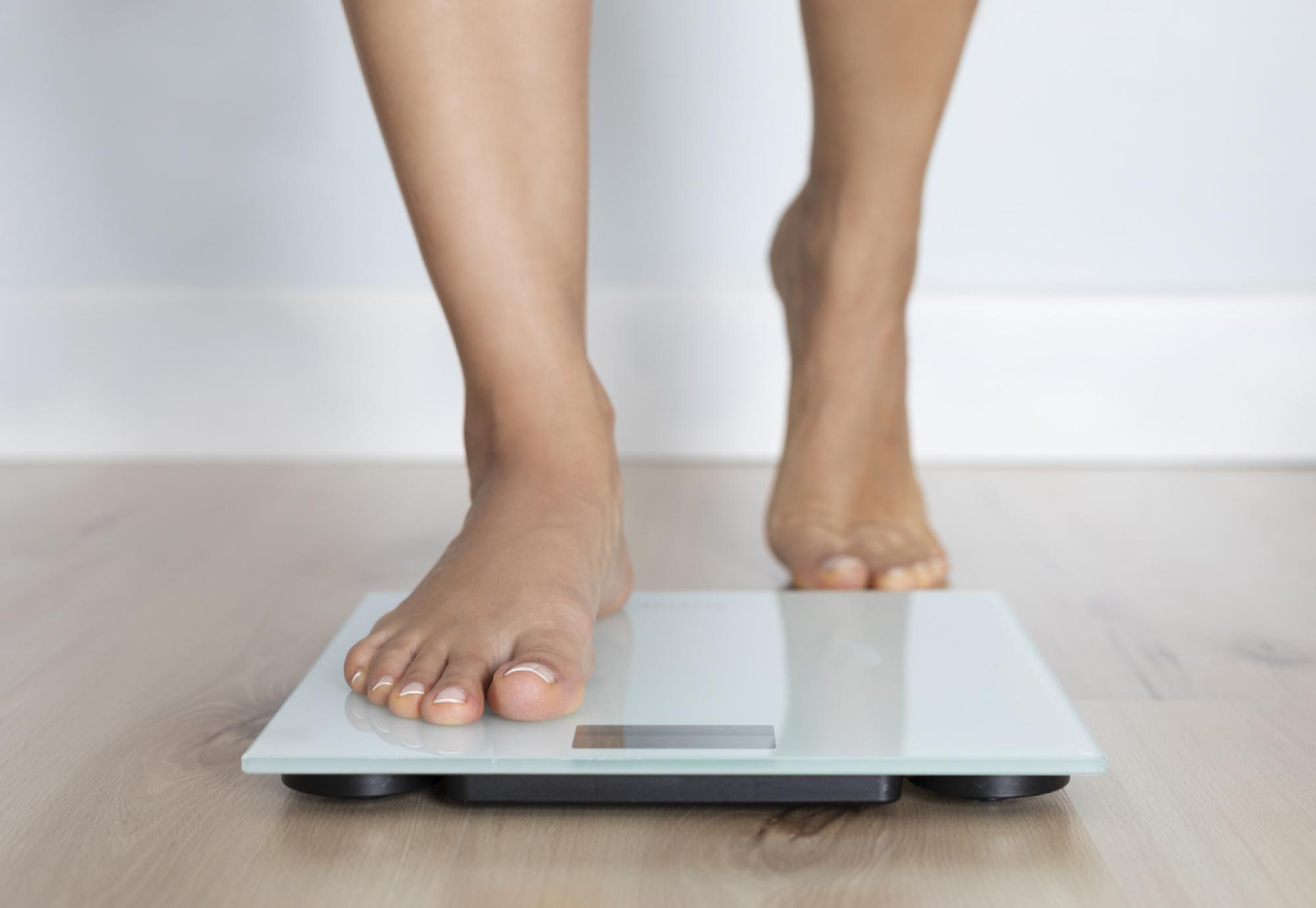 Woman getting on a weighing scale