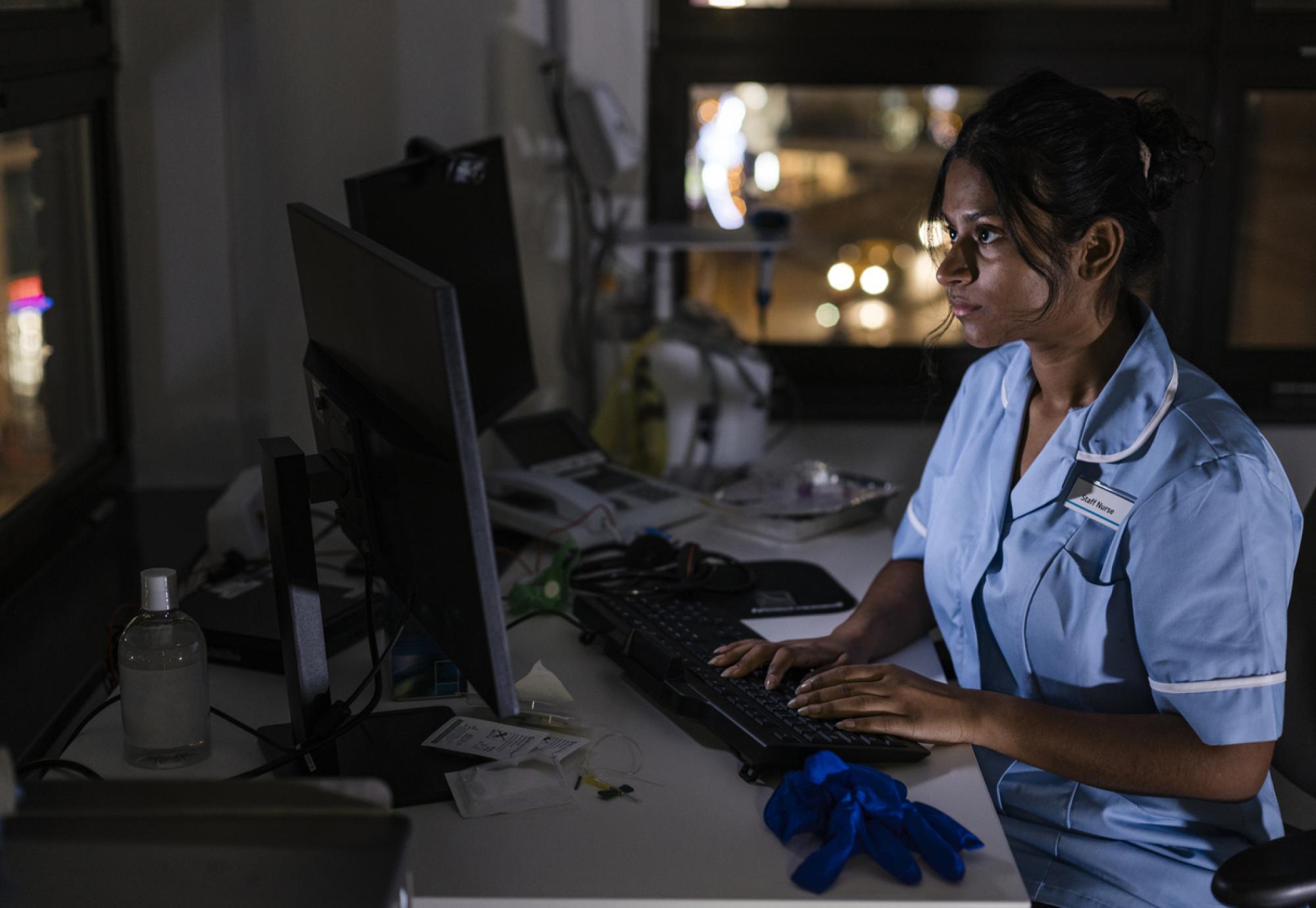 Side view of a nurse using a computer