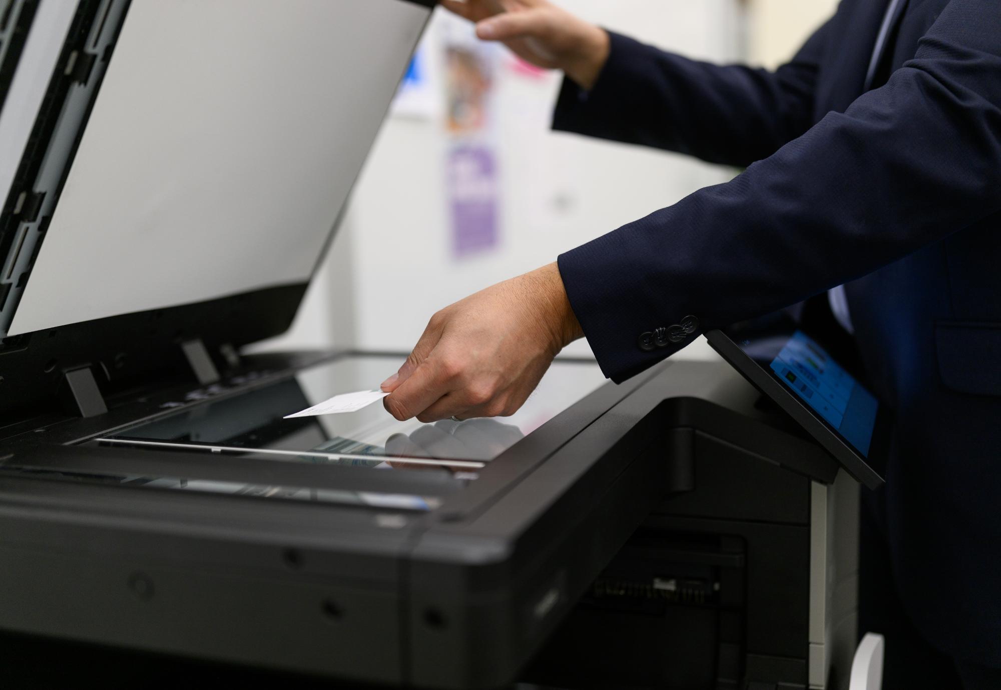 Person placing business card in a scanner