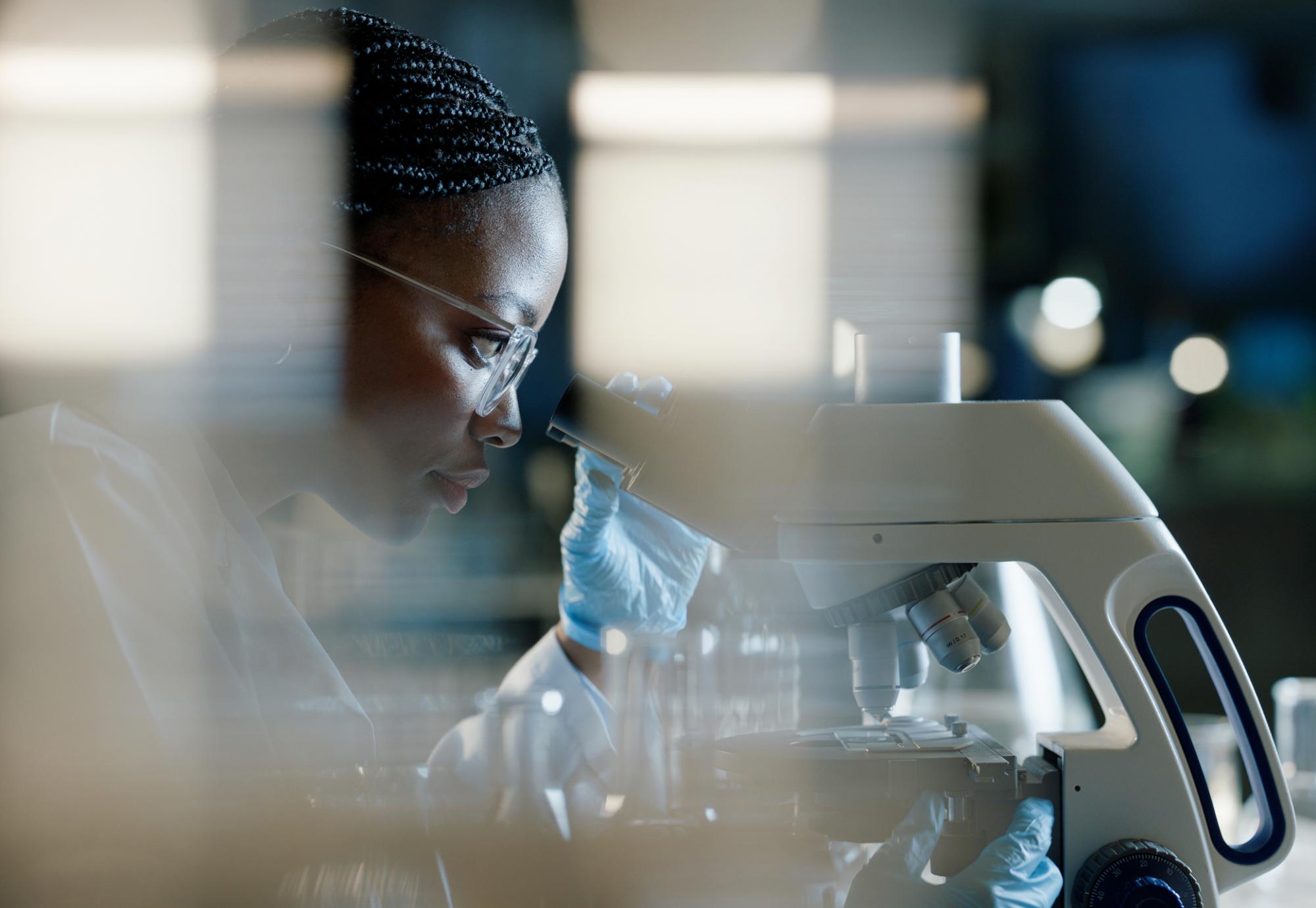 Scientist using a microscope for health research