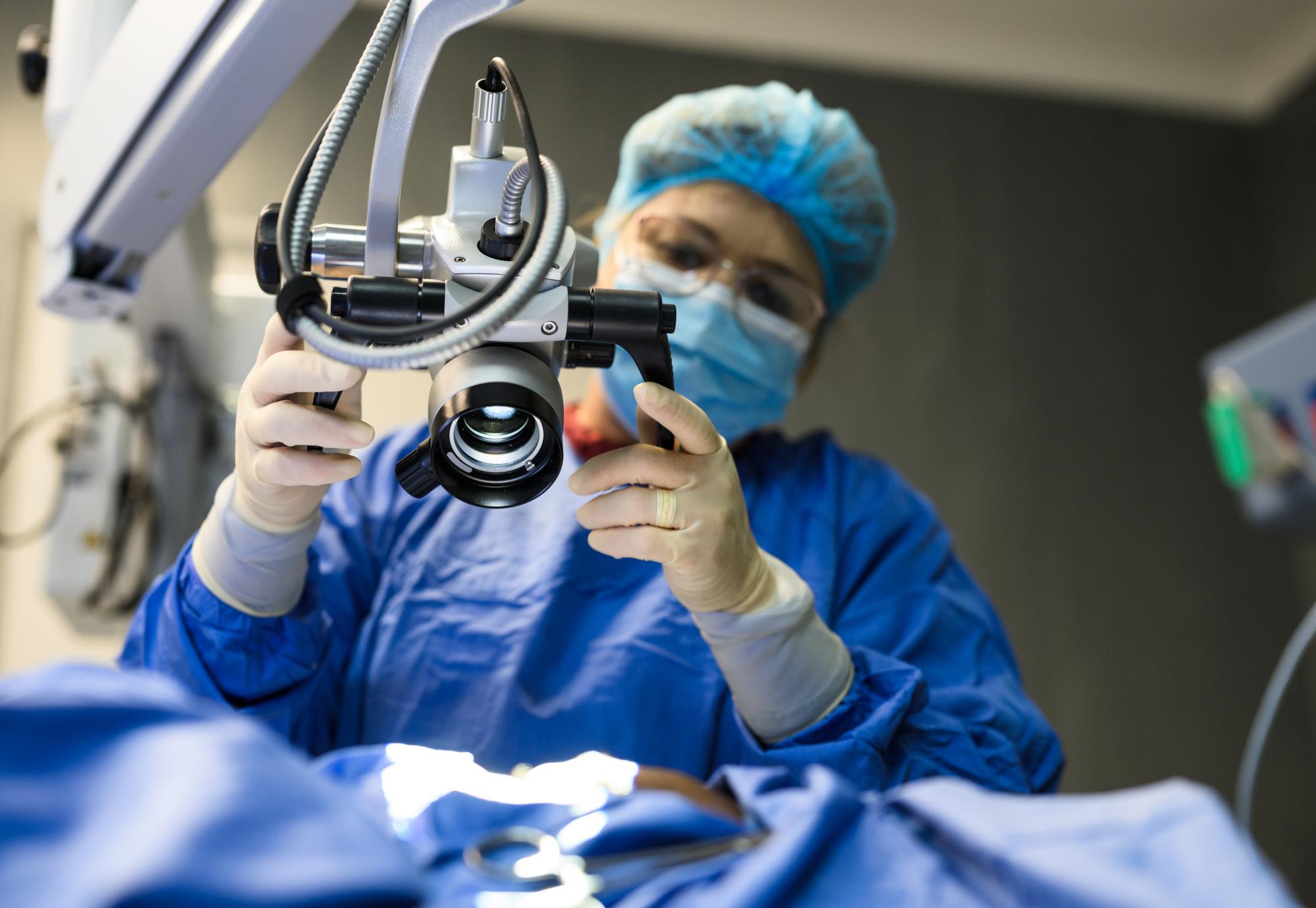 Female doctor positioning microscope