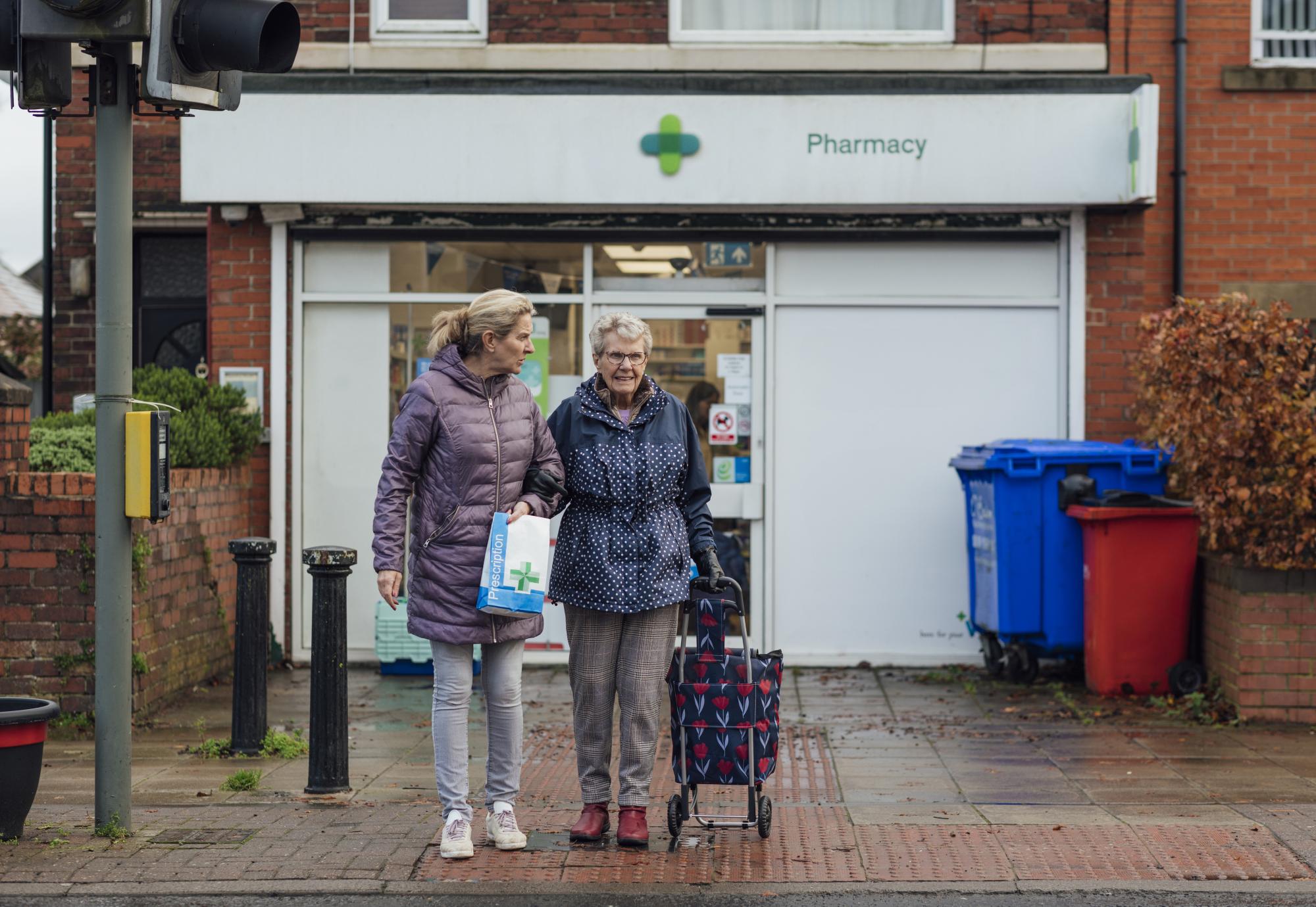 Two people leaving a pharmacy
