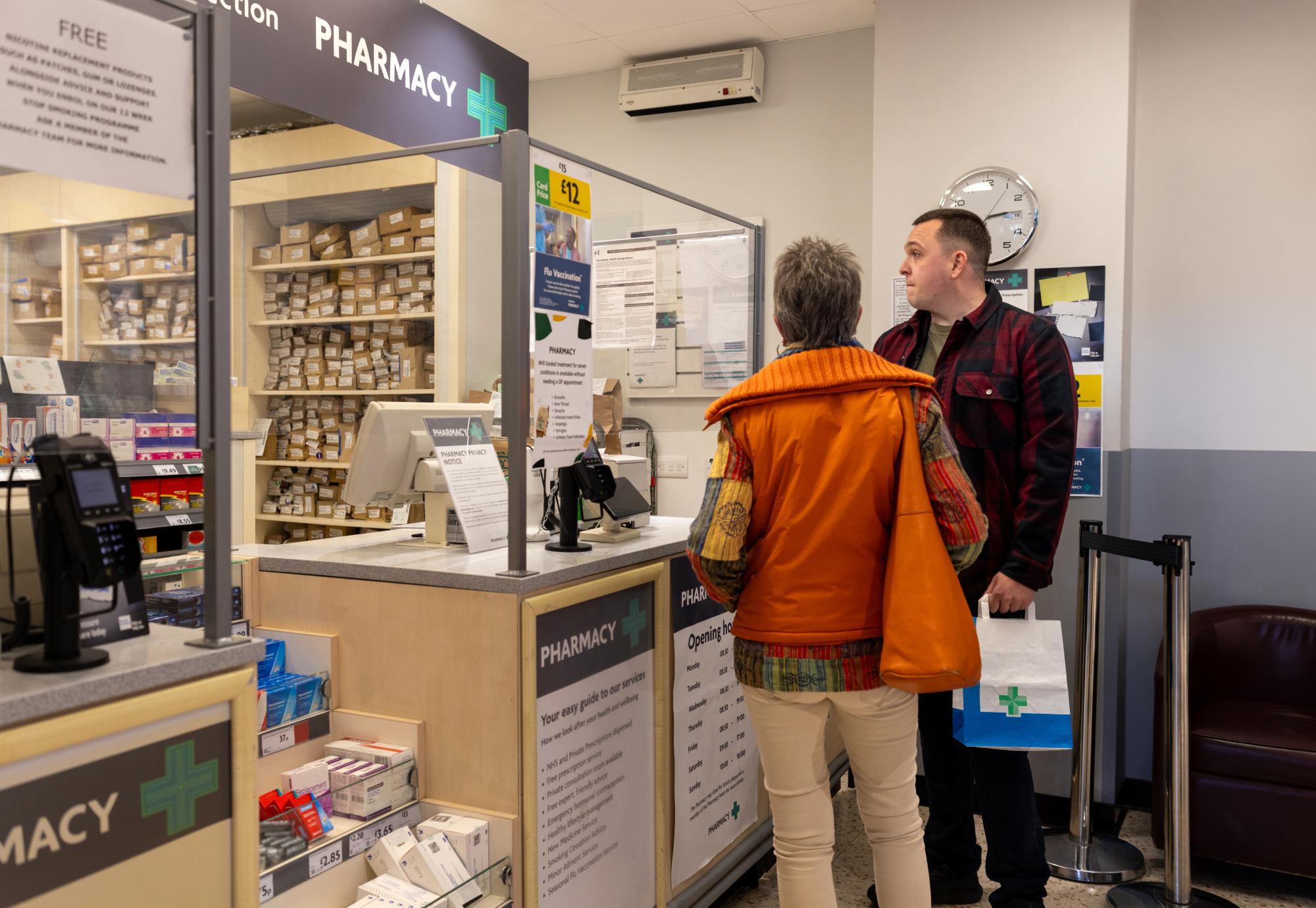 Two people picking up prescriptions