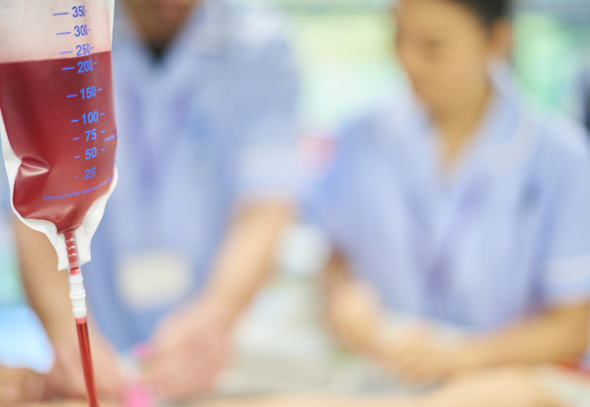 A blood bag with nurses in the background