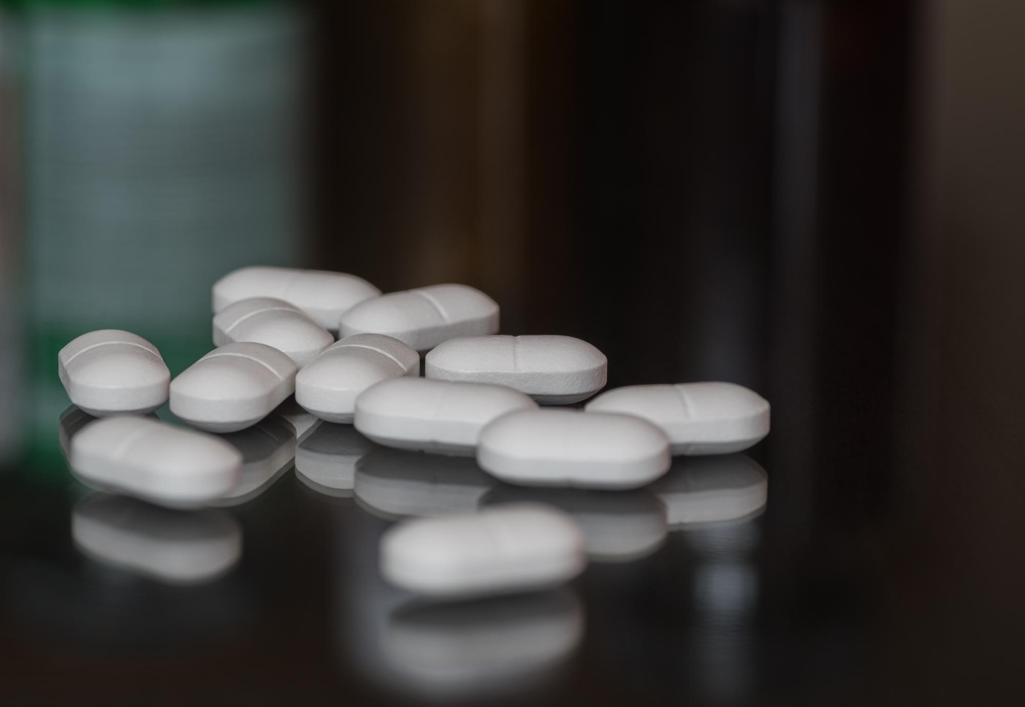 White pills on a dark surface