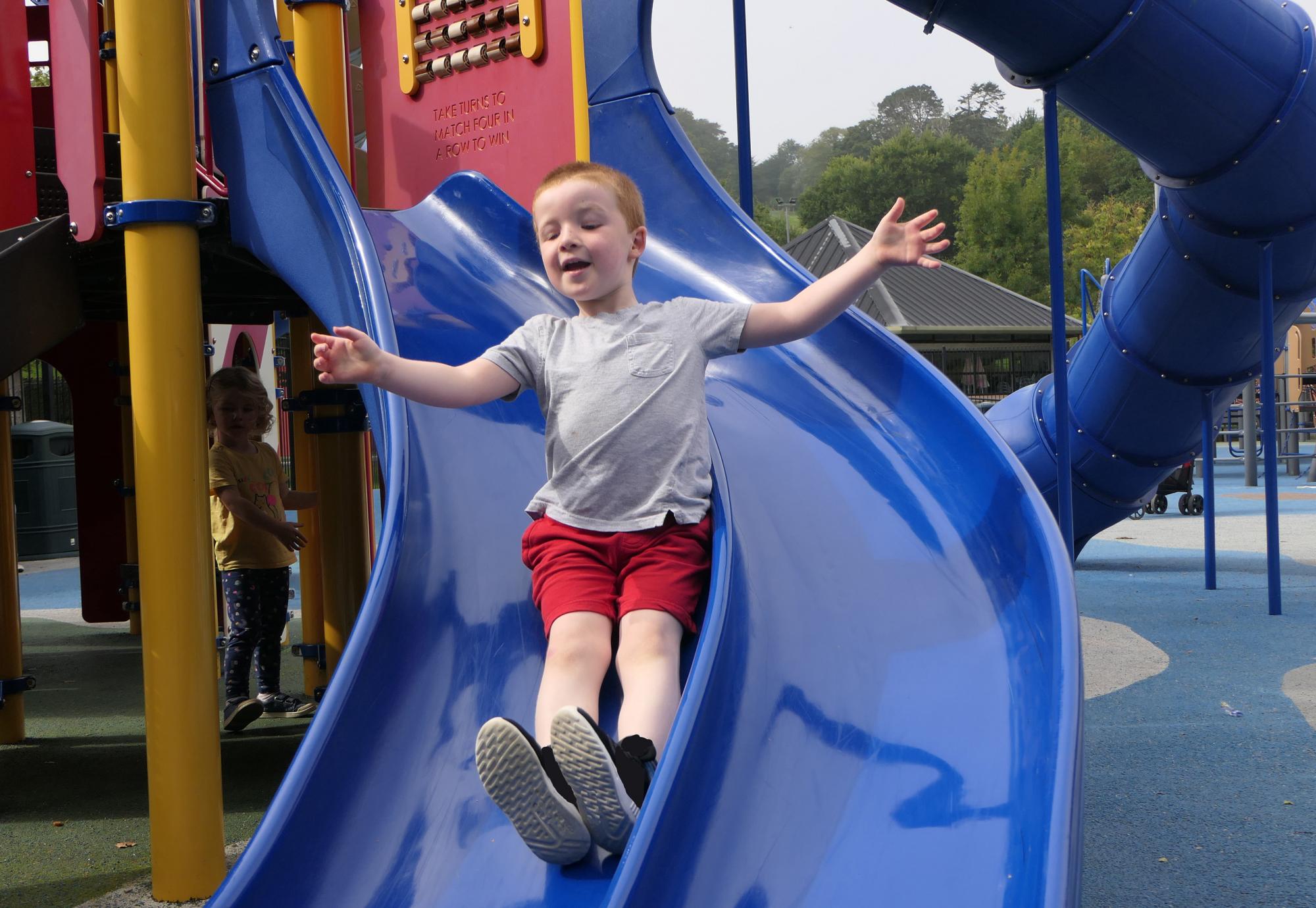 Young child playing on slide