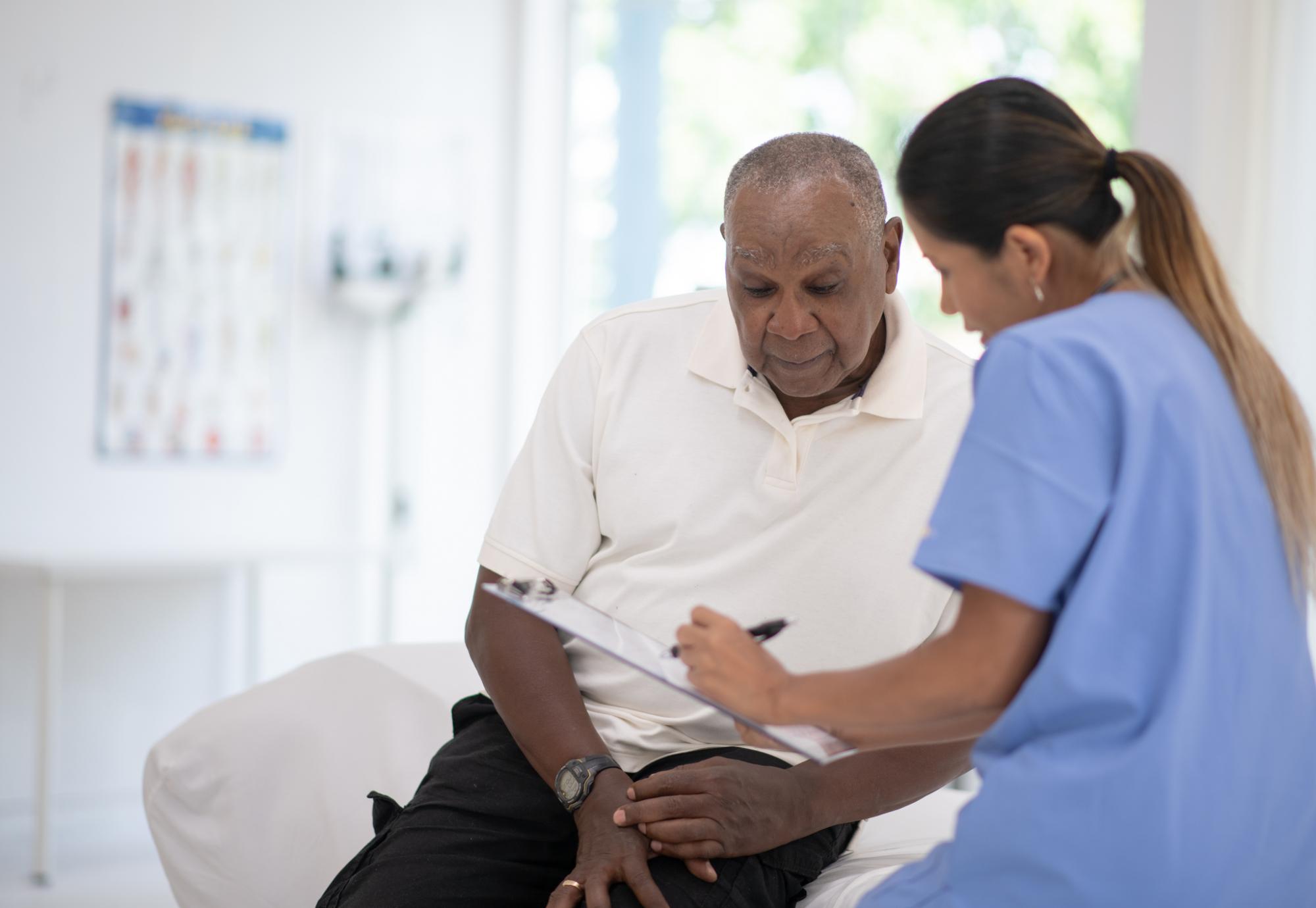An older gentleman talks to a nurse about prostate cancer