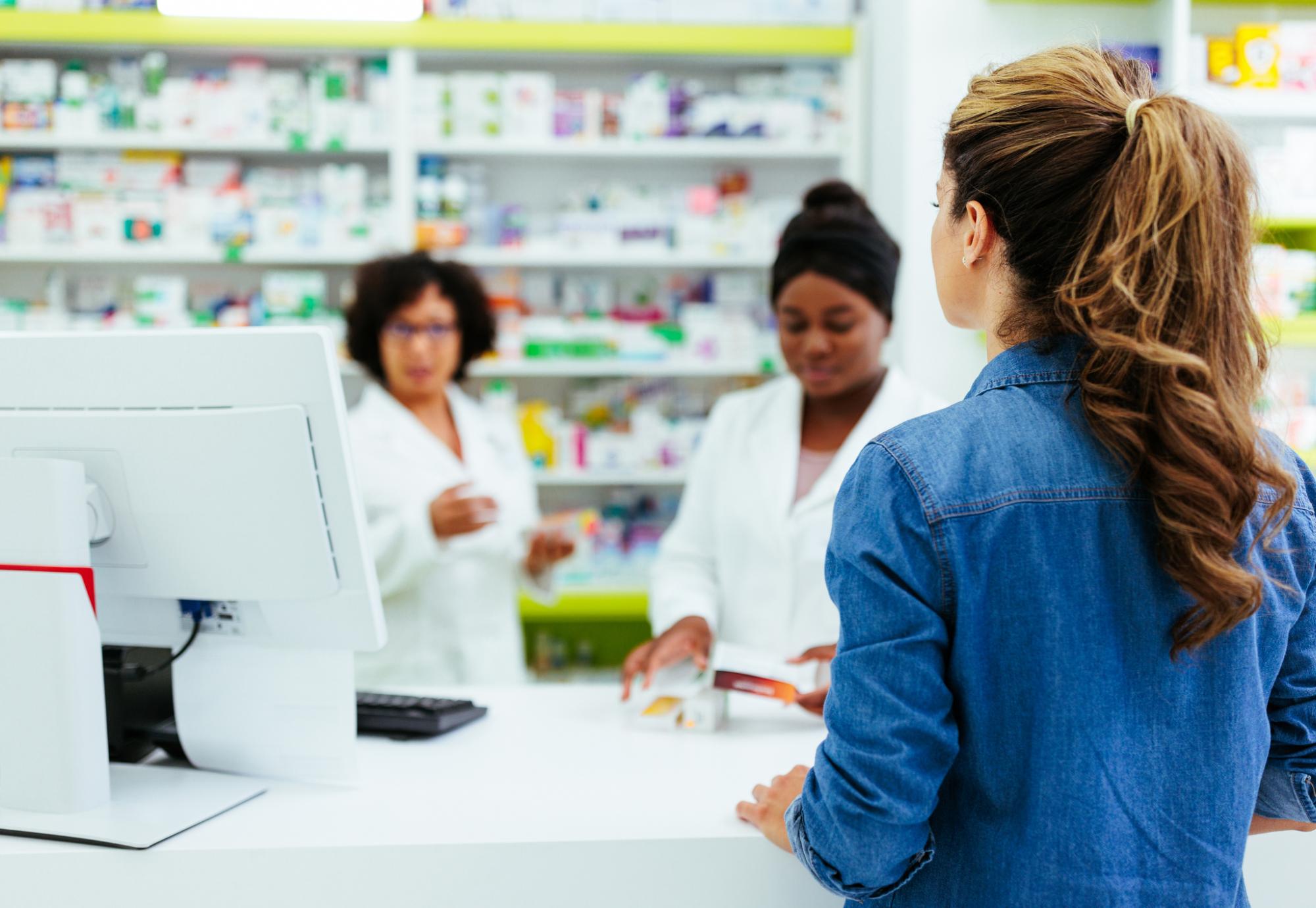 Young woman talking to pharmacists
