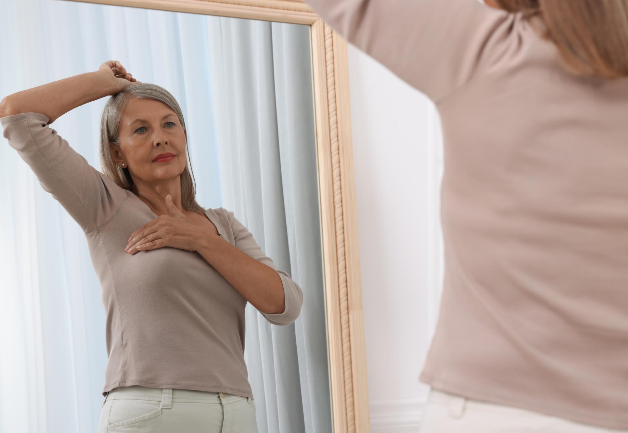 Senior woman checking for breast cancer
