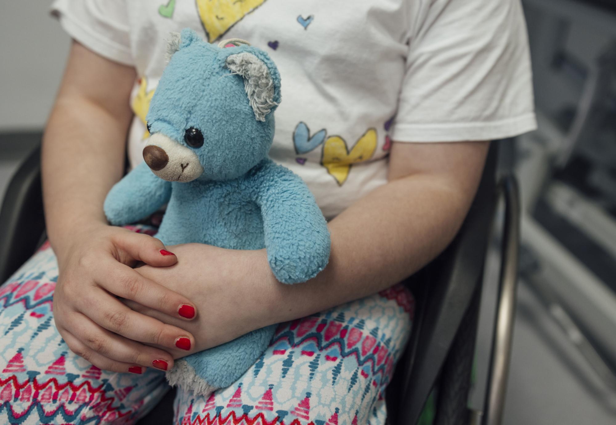 Small child holding a teddy bear